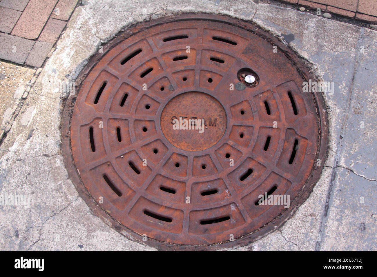 Tombino in ghisa con coperchio la parola vapore. Foto Stock