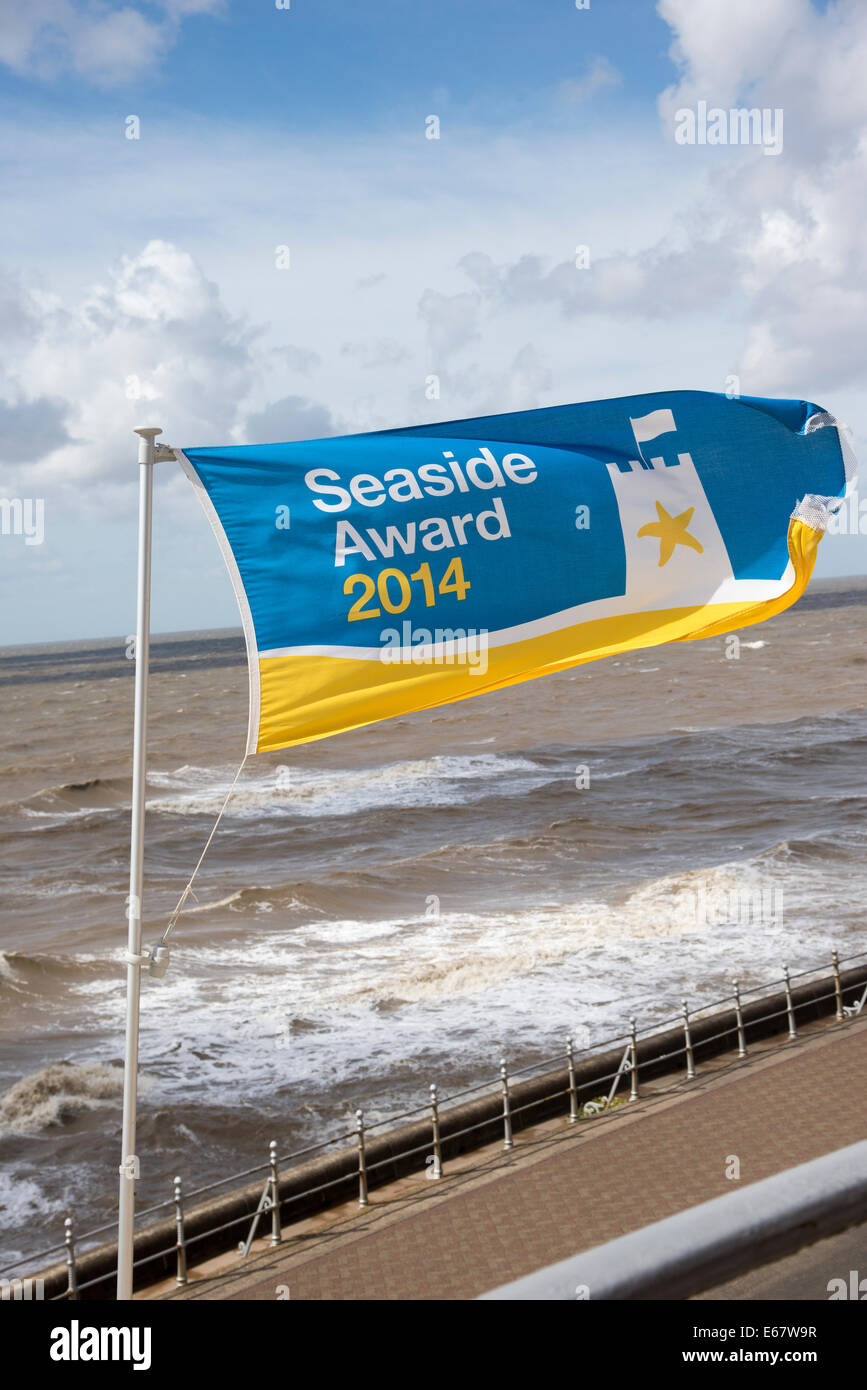 Premio Mare Bandiera volando sul litorale a Blackpool Lancashire England Regno Unito un vivace vento che soffia attraverso il mare in estate Foto Stock