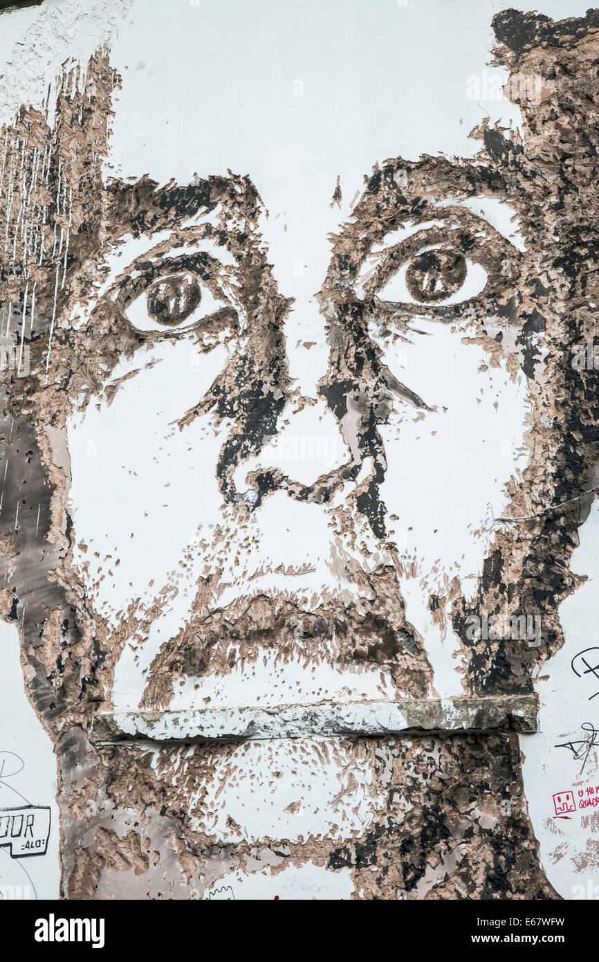 Un ritratto creato in cavava-out di cemento in un vicolo di parete vicino a Brick Lane di Alexandre Farto aka Vhils Foto Stock