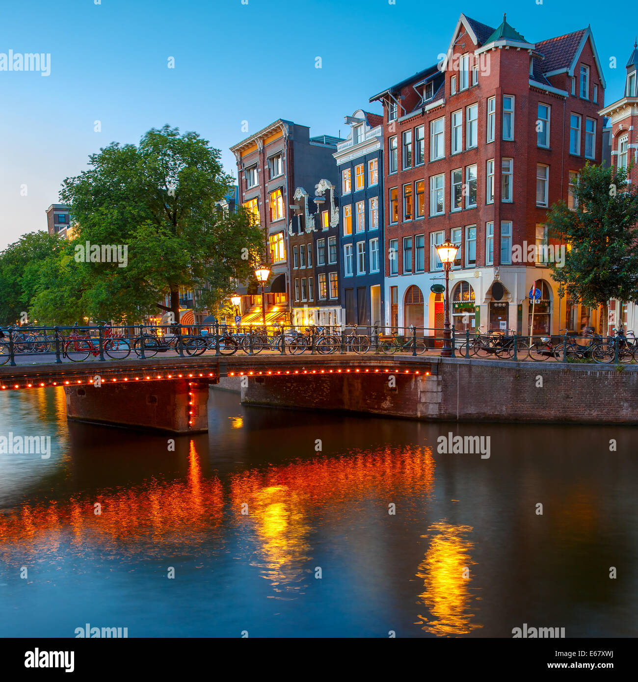 Notte Vista sulla città di Amsterdam canal, tipiche case olandese e il ponte, Holland, Paesi Bassi. Foto Stock