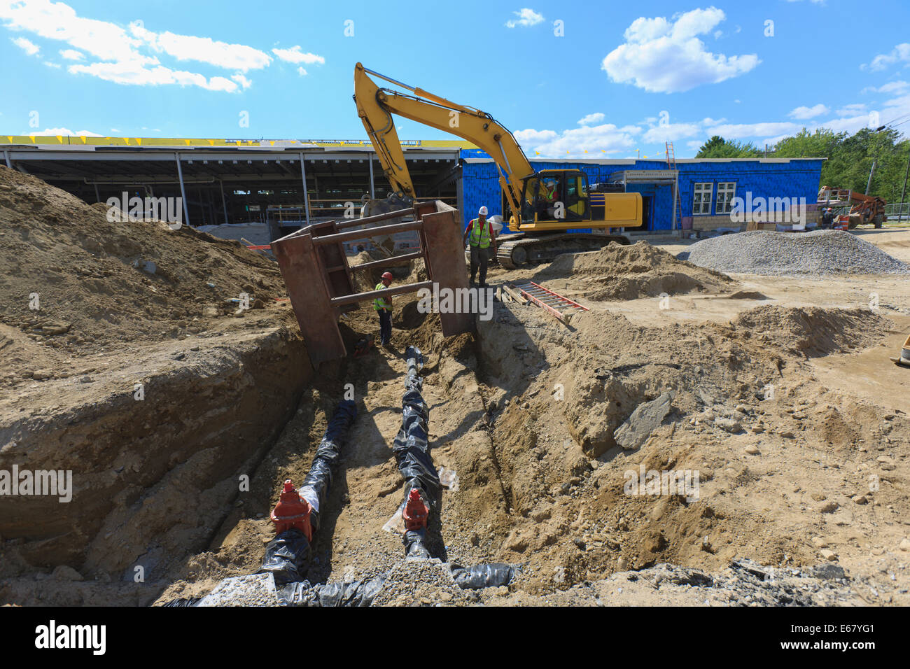 Escavatore e trincea scudo per lavoratori edili a tubo acqua sito di posa Foto Stock