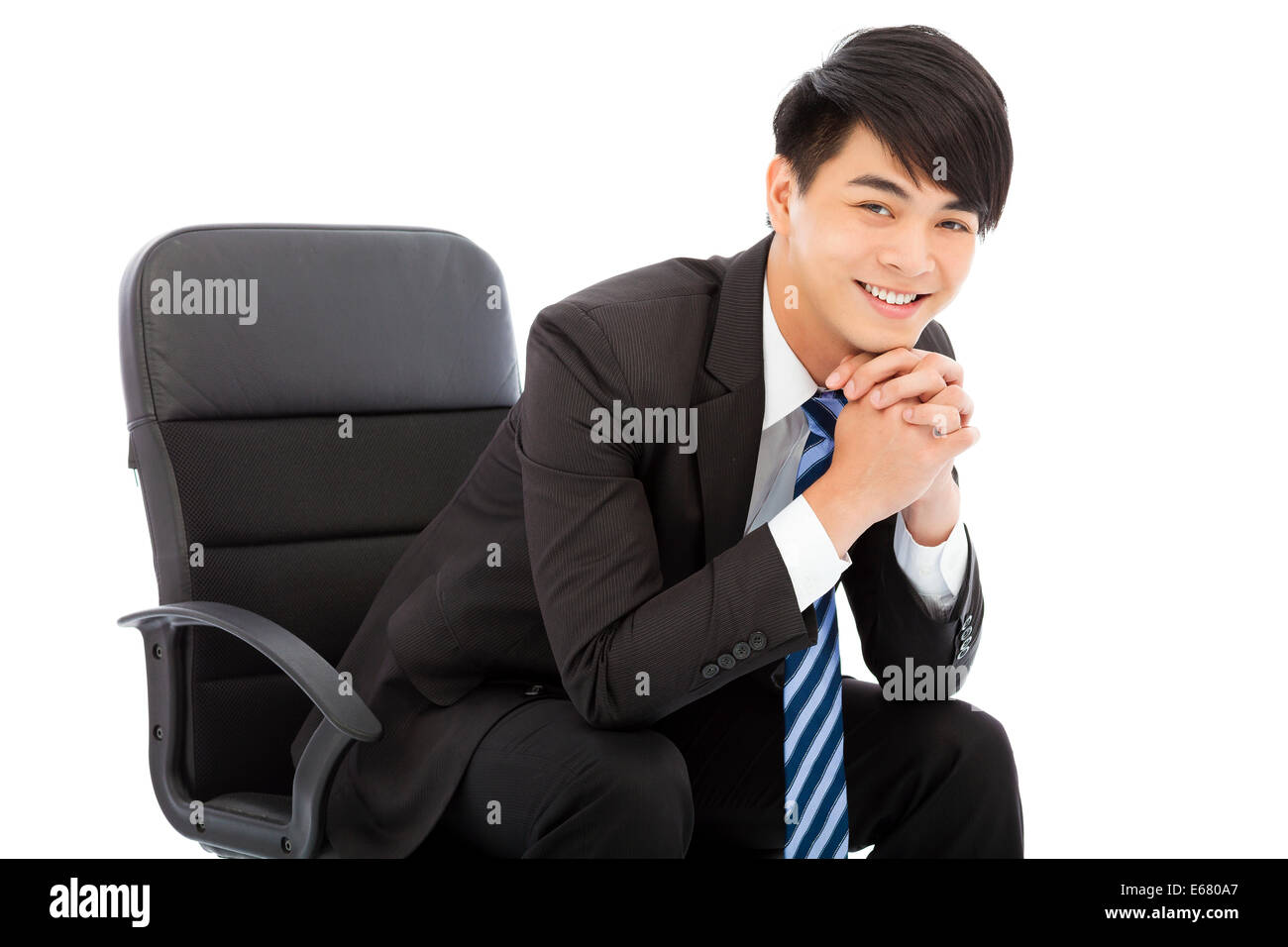 Sorridente imprenditore giovane seduto su una sedia Foto Stock