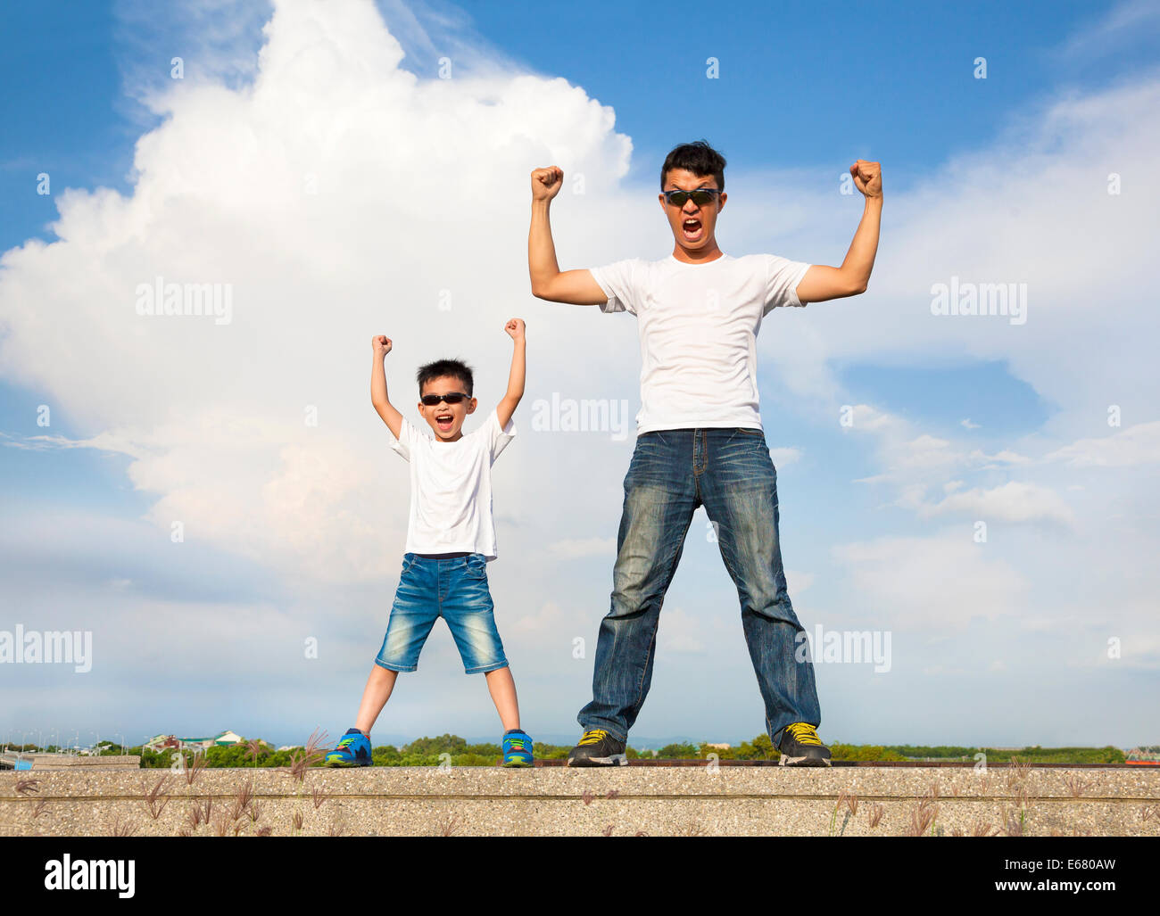 Padre e figlio in piedi e mani di sollevamento Foto Stock
