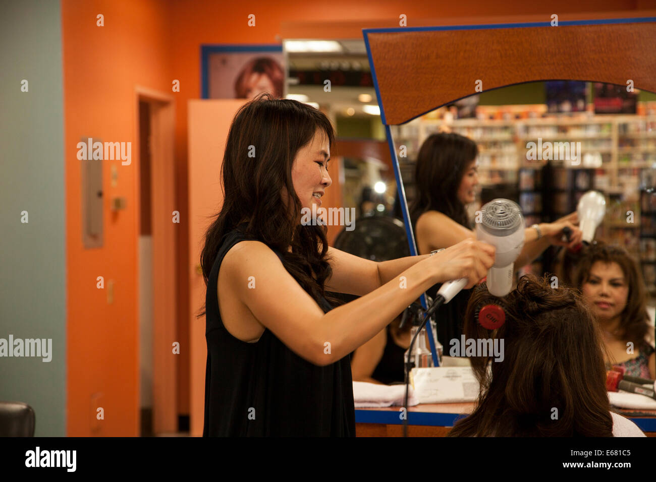 Parrucchiere vietnamita lavorando alla sua tipologia dei capelli del cliente, Westminster, Orange County, California, Stati Uniti d'America Foto Stock