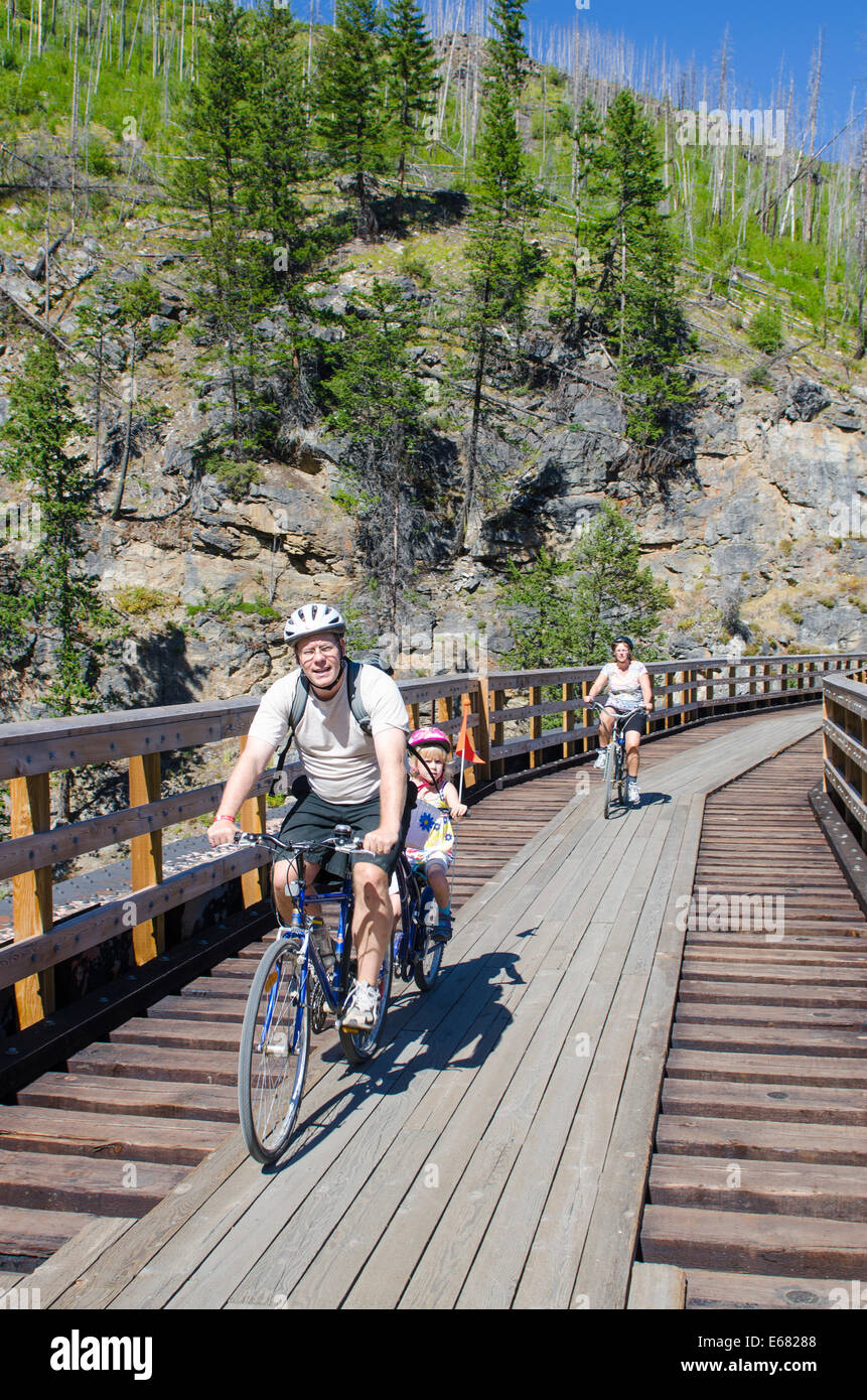 Famiglia mountain bike Escursioni in bicicletta equitazione vecchia ferrovia in legno tralicci trail in Myra Canyon, Kelowna, British Columbia, Canada. Foto Stock