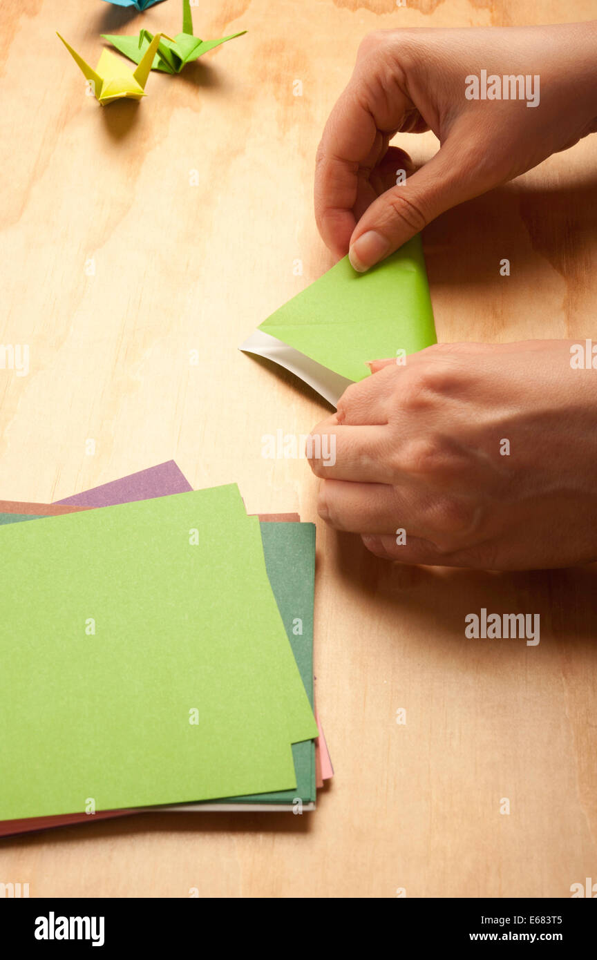 Donna piegando la carta per origami Foto Stock