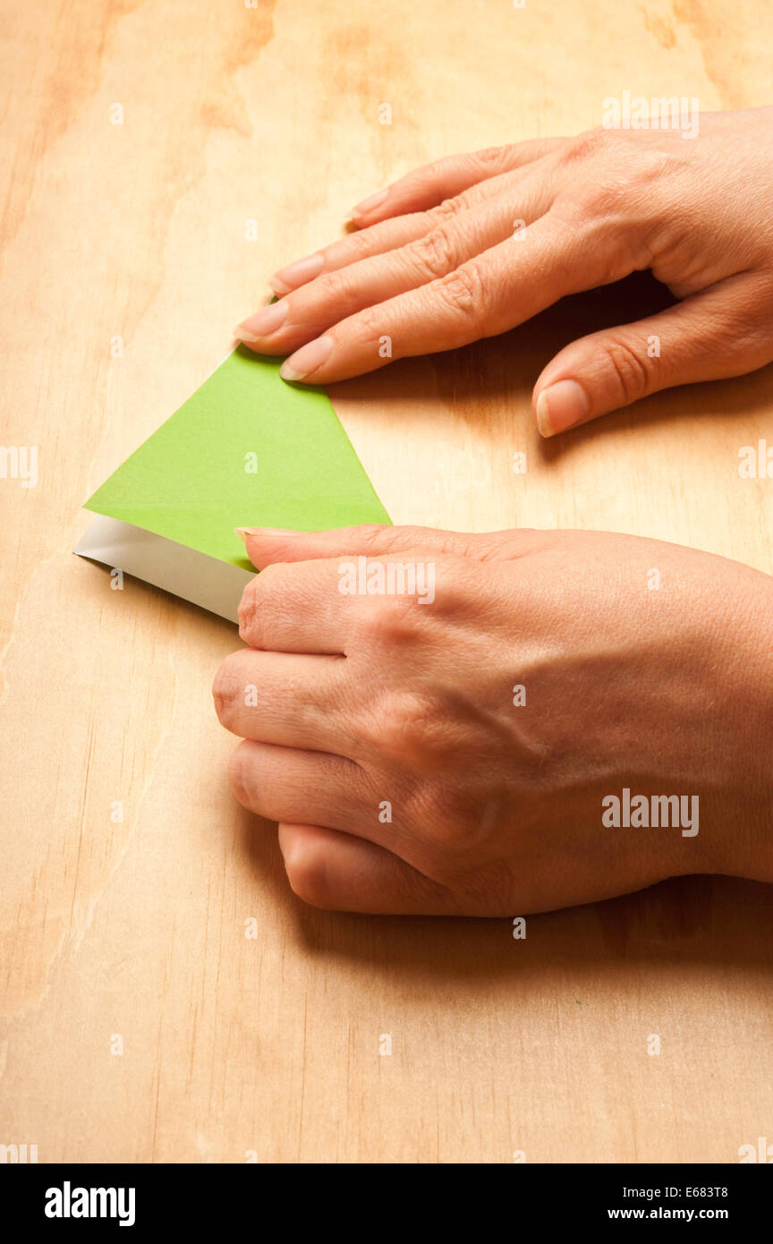 Donna piegando la carta per origami Foto Stock