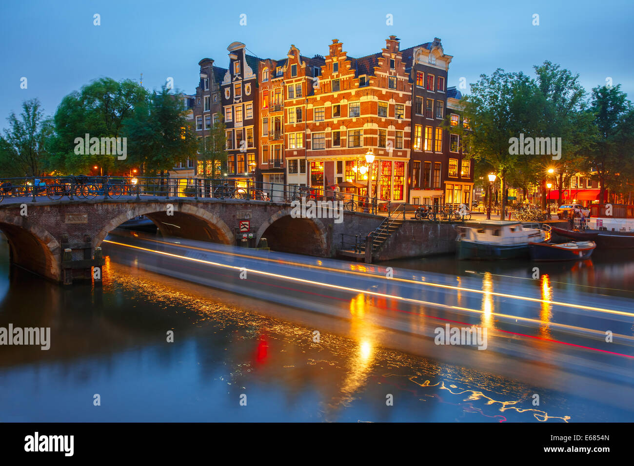 Notte Vista sulla città di Amsterdam canal, il ponte e le tipiche case, barche e biciclette, Holland, Paesi Bassi. Foto Stock