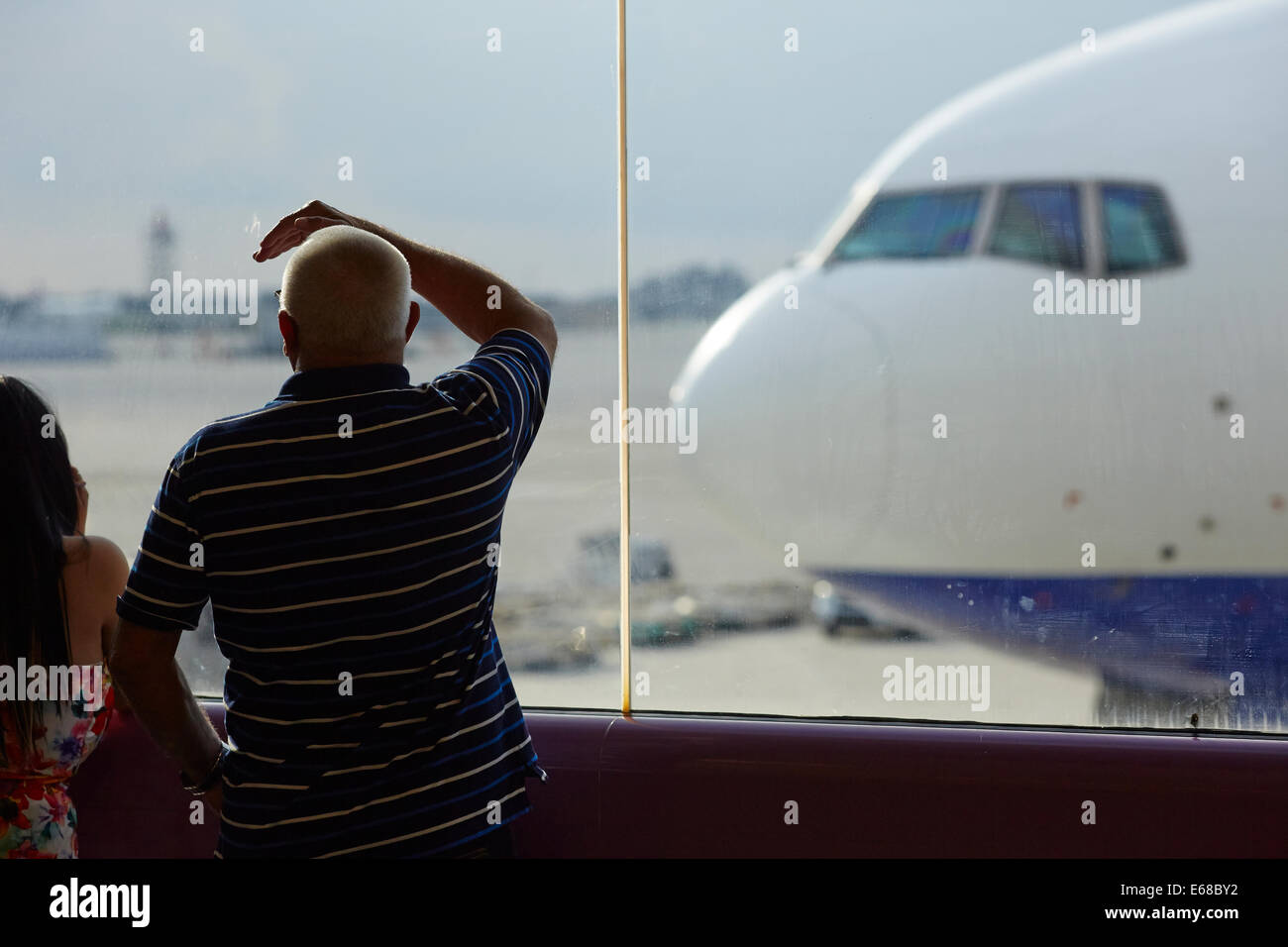 Il passeggero guardando attraverso il vetro a compagnie aeree Ransaero piano Beoing 777 Foto Stock