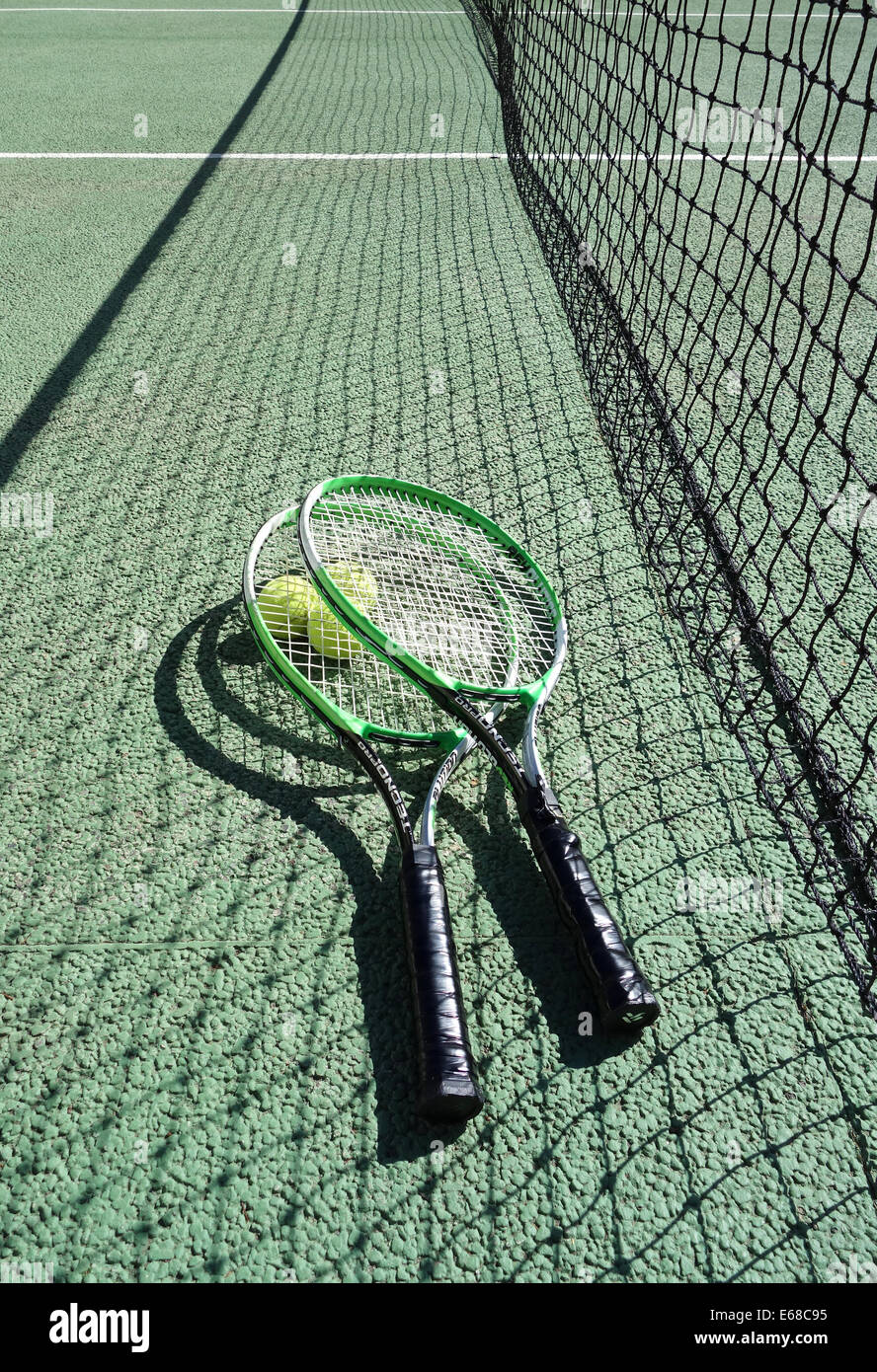 Campo da tennis, racchette e palline da tennis su un campo da tennis che mostra net. Campo da tennis Foto Stock