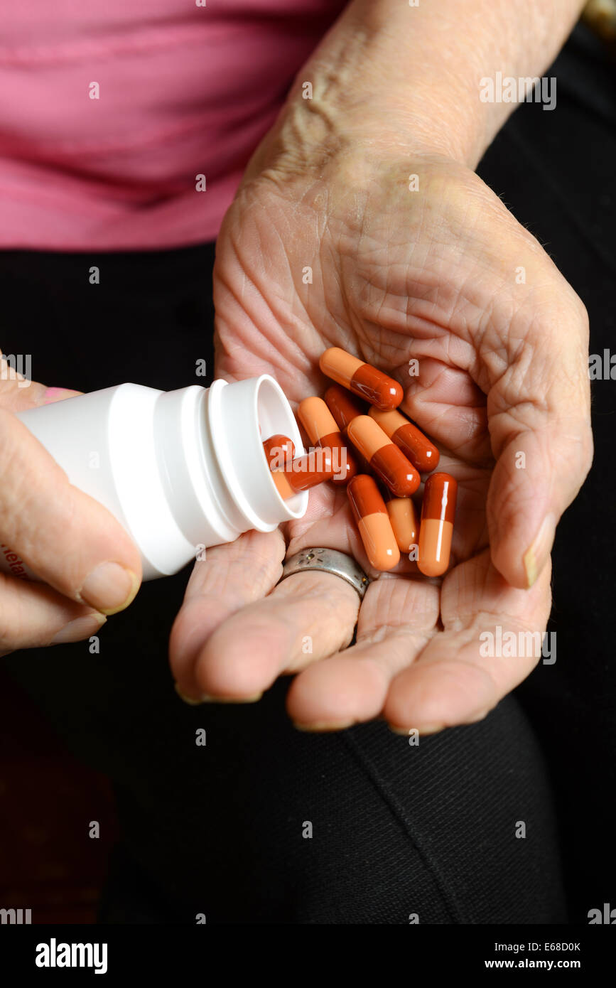 Anziani mani compresse, pillole, farmaco. Vecchia donna con le mani in mano che mostra le capsule o pillole Foto Stock