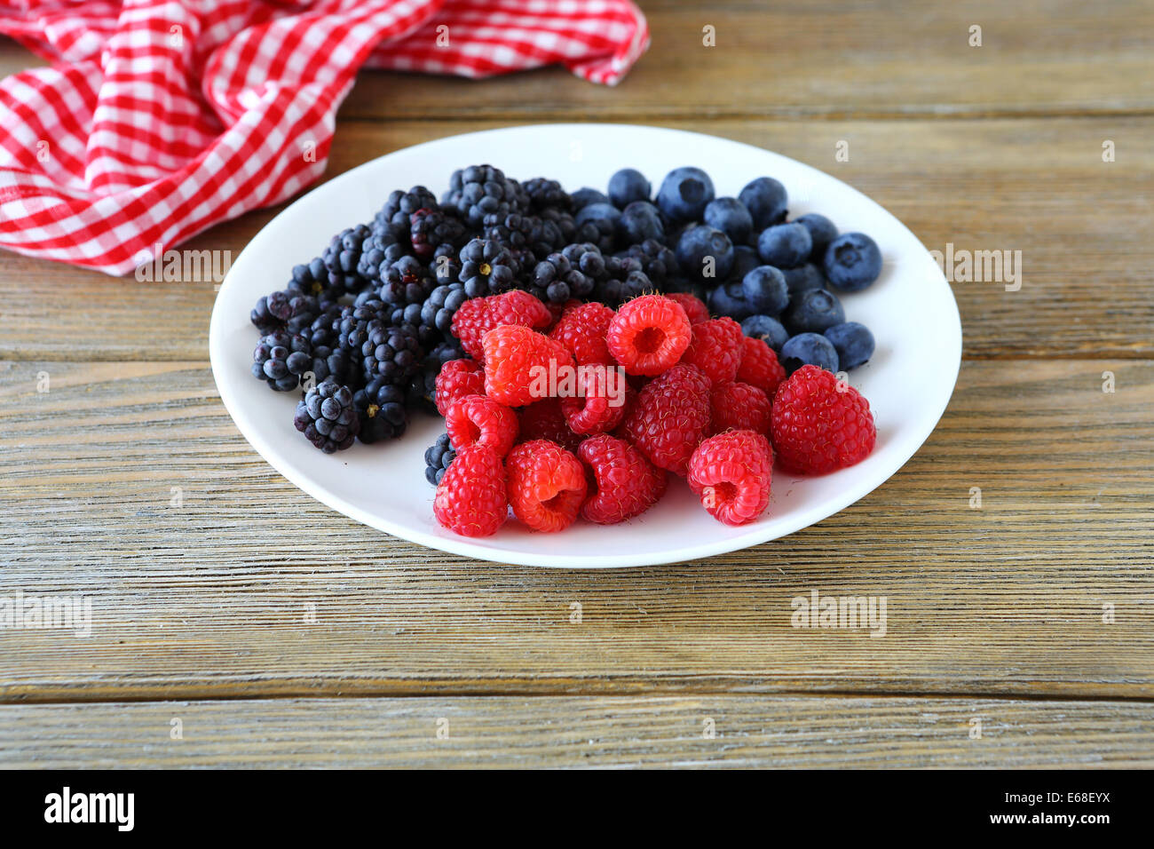 Mix di frutti di bosco freschi su una piastra, cibo closeup Foto Stock
