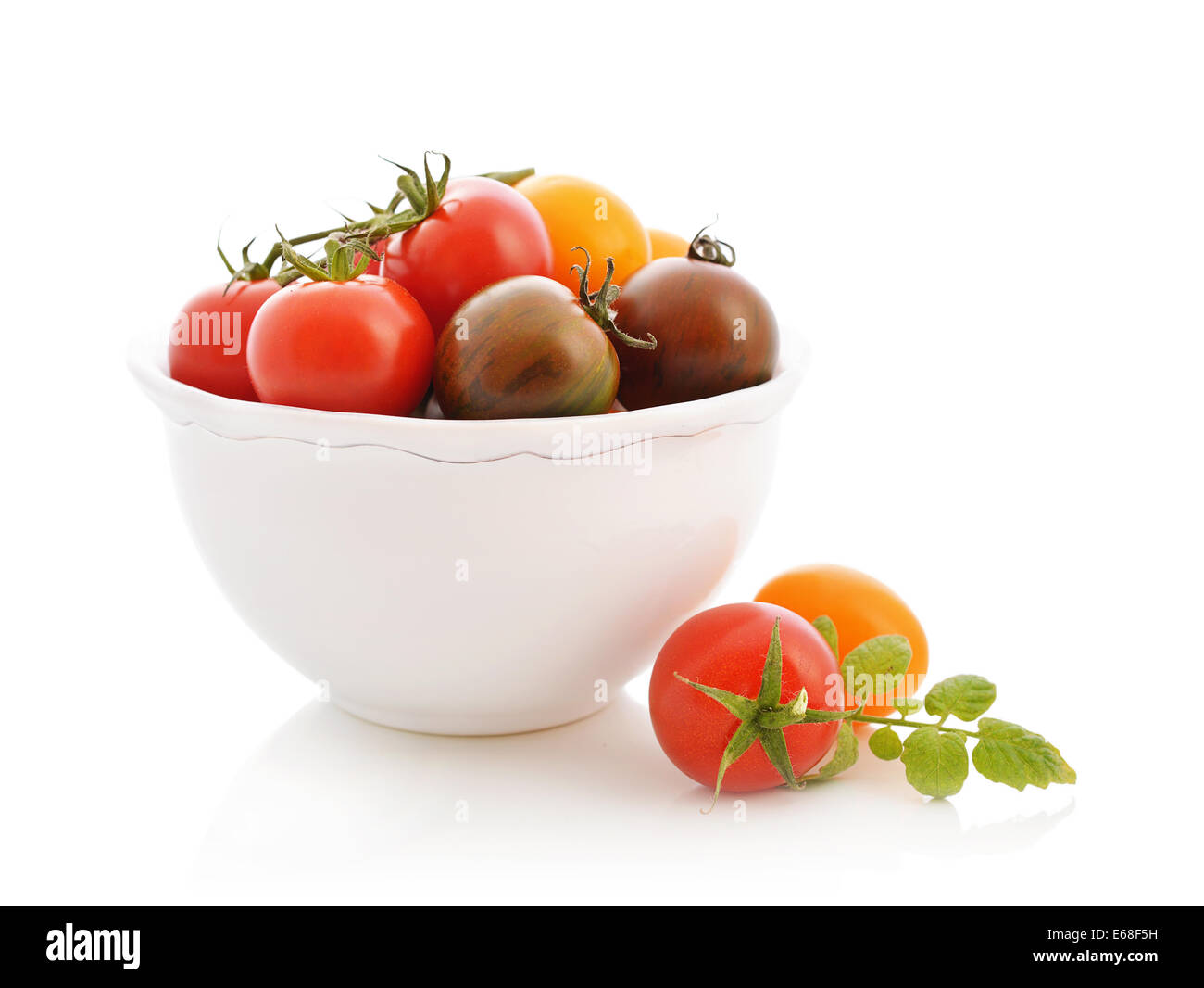 Diverse varietà di pomodoro nel recipiente isolato su bianco Foto Stock