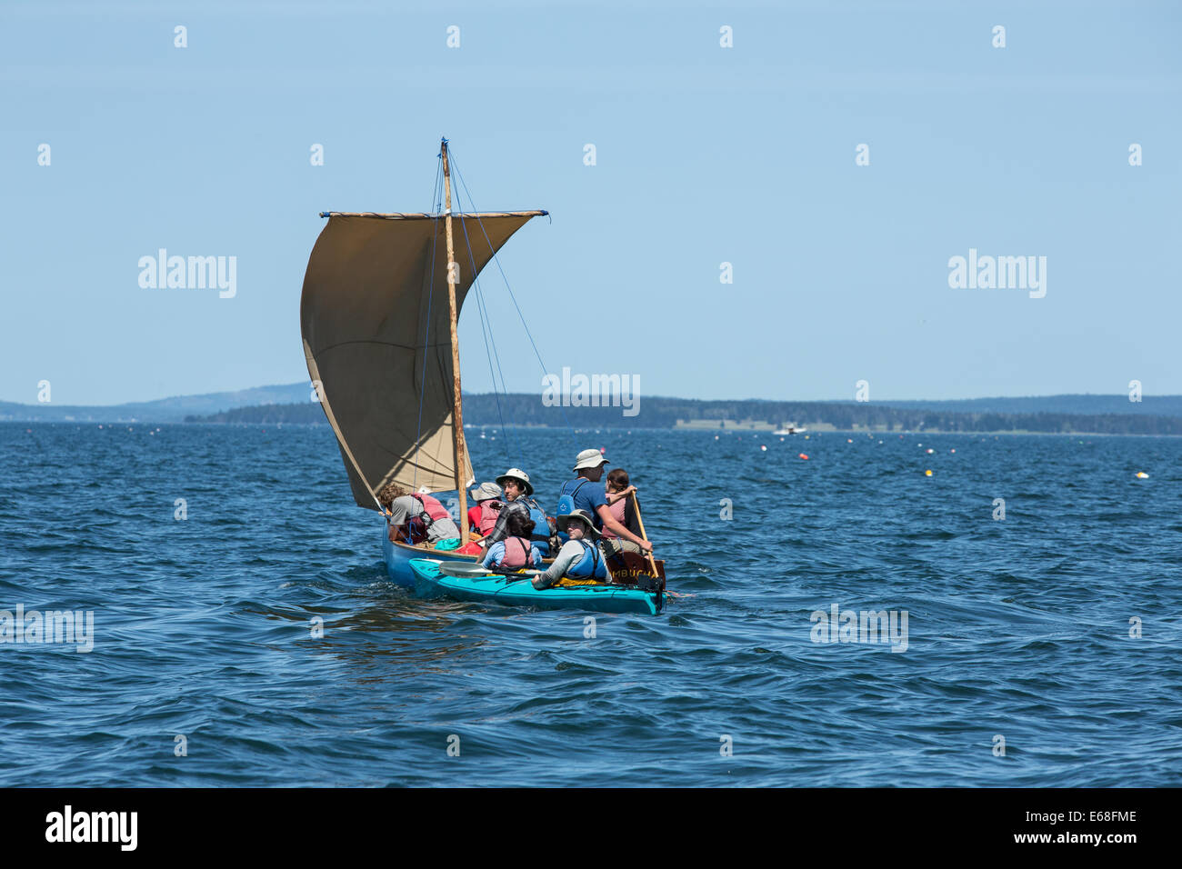 Baia di Penobscot, ME - 12 agosto 2014. Piazza-sterned vela canoa Il Kombucha, con un kayak a fianco, vela fino alla baia. Foto Stock