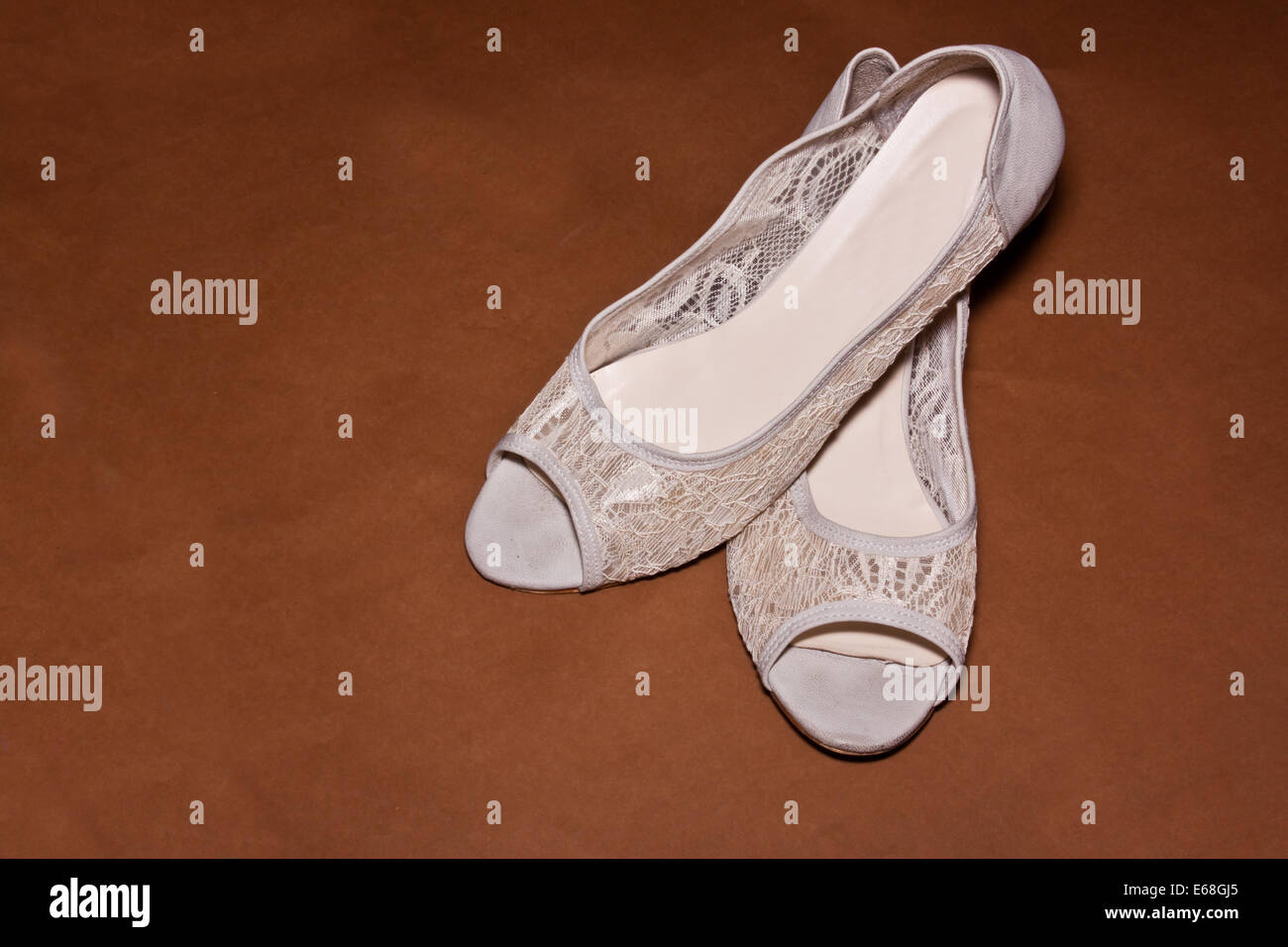 Sneaker bianco su sfondo marrone Foto Stock