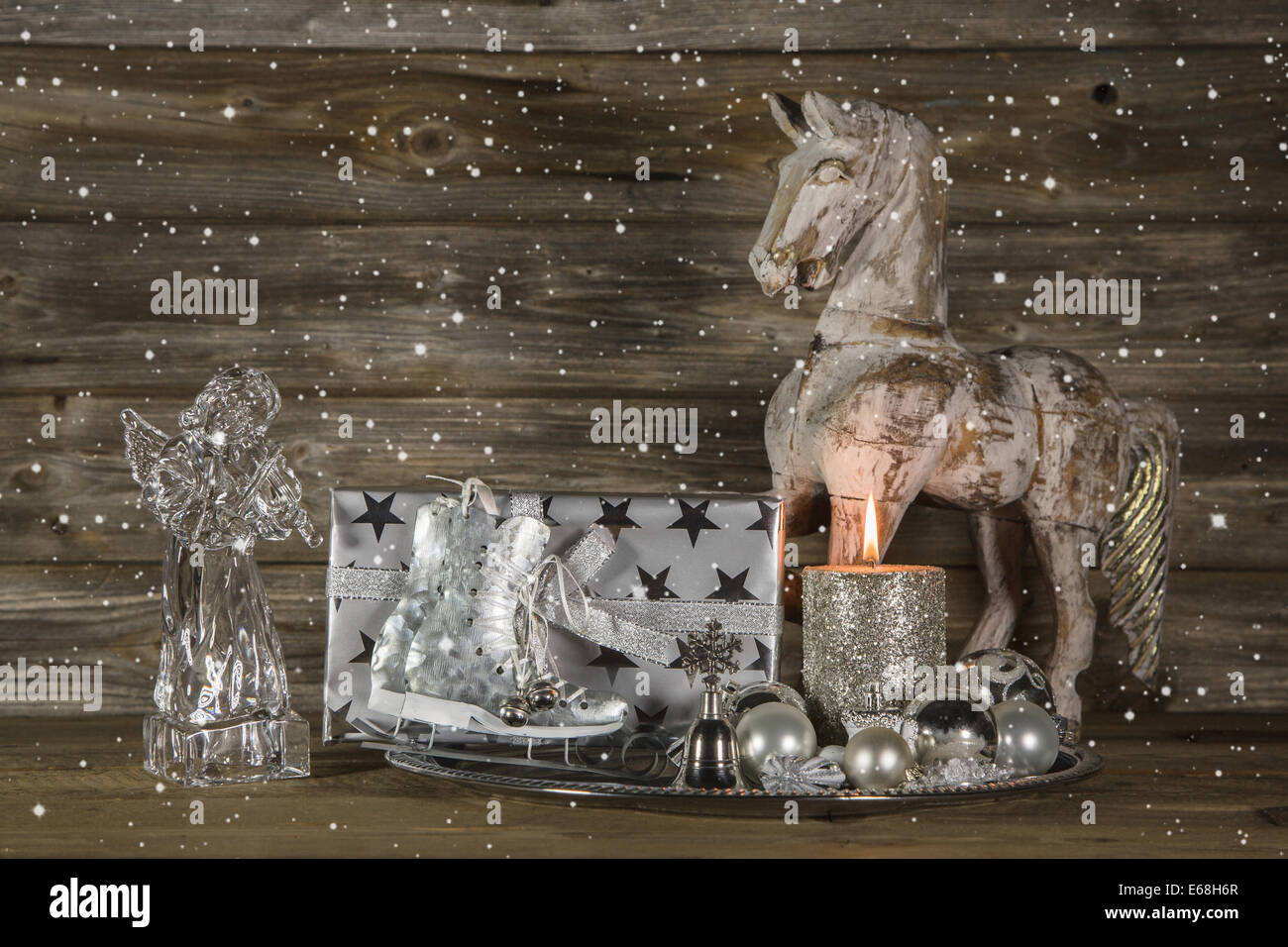 Argento e Beige decorazione di Natale con la presente, Angelo, il cavallo e la candela che brucia su sfondo di legno. Foto Stock