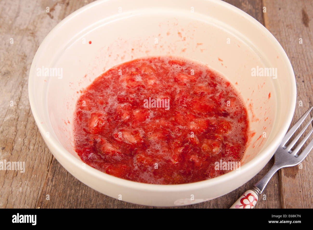 Fragola mescolati con lo zucchero nel recipiente Foto Stock