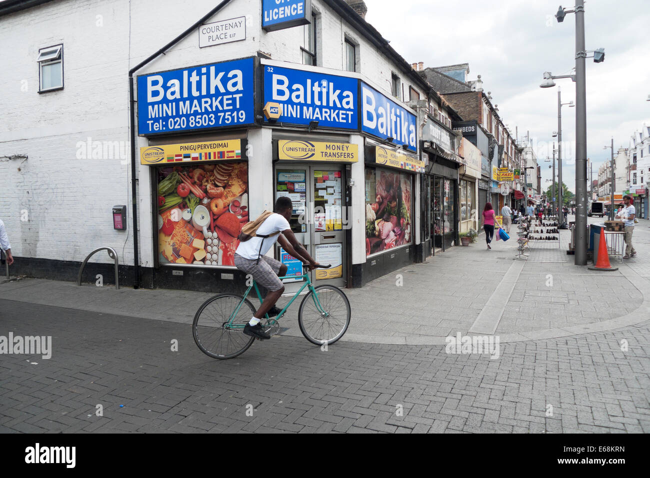 Uomo in bicicletta pas Baltika mini sul mercato di Walthamstow High Street London E17 REGNO UNITO KATHY DEWITT Foto Stock