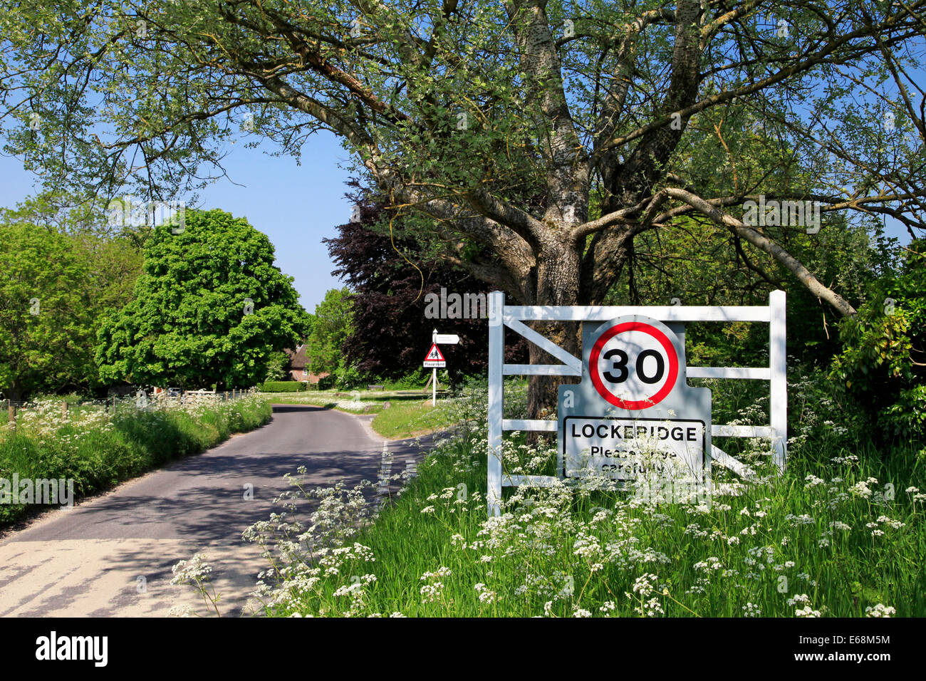 Il villaggio e il segnale di limite di velocità a Lockeridge, nella Kennet Valley vicino a Marlborough, Inghilterra, Regno Unito. Foto Stock