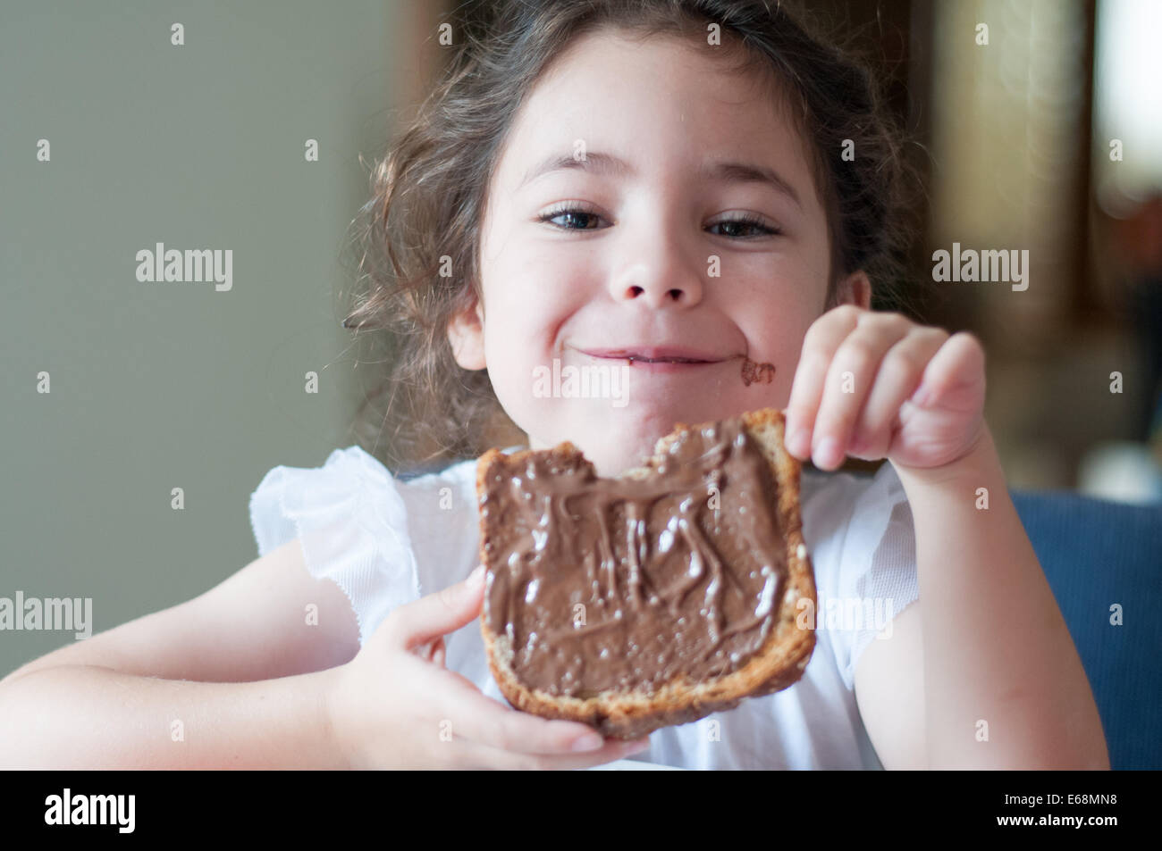 Bambino mangiare pane con cioccolata spalmabile Foto Stock