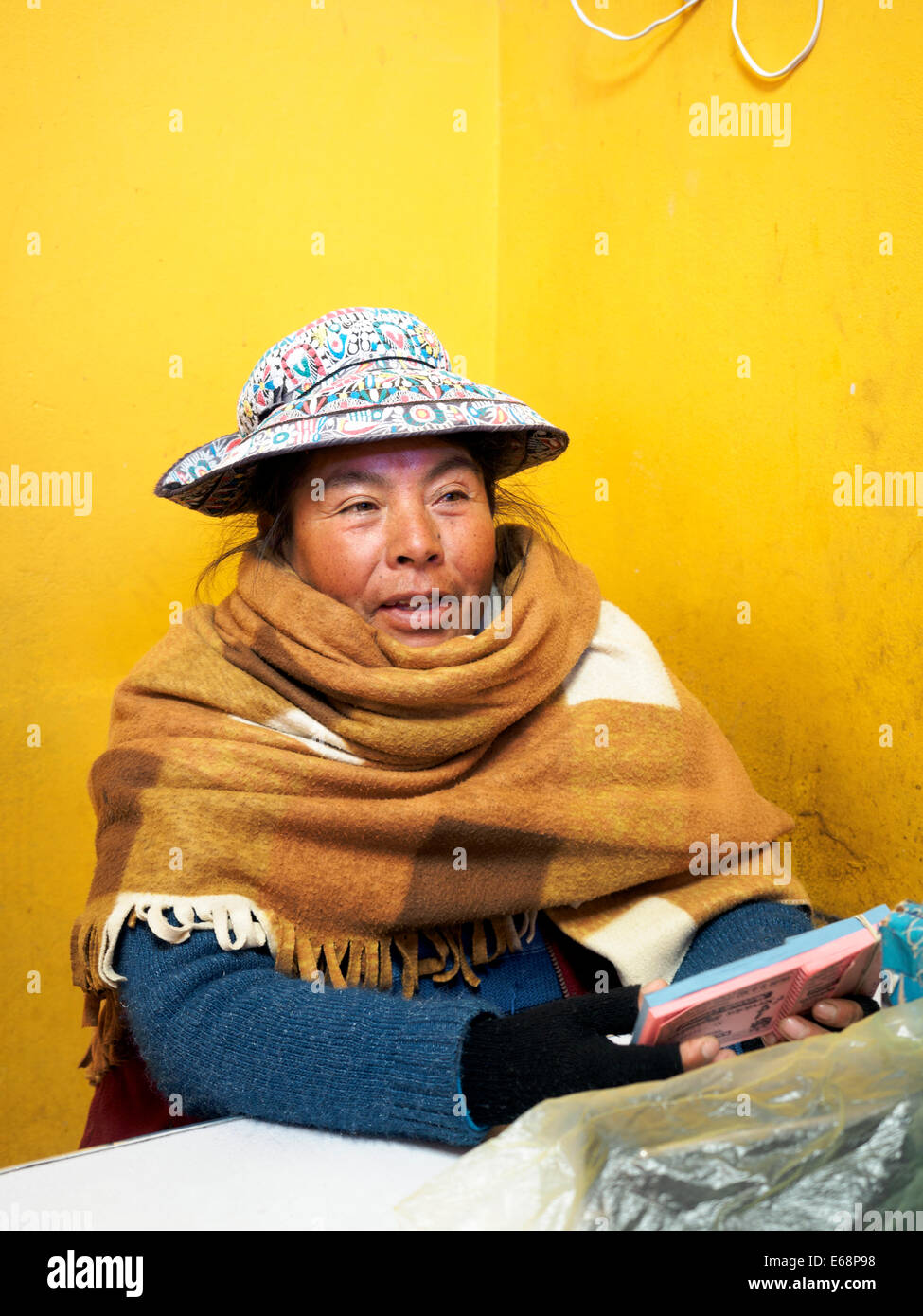 Local donna in abiti tradizionali la vendita di biglietti per i servizi igienici pubblici - Chivay, Perù Foto Stock
