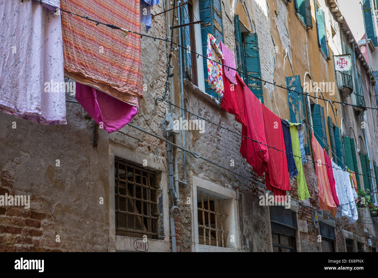Abiti colorati appesi sulla linea fuori casa vecchia a Venezia. Foto Stock