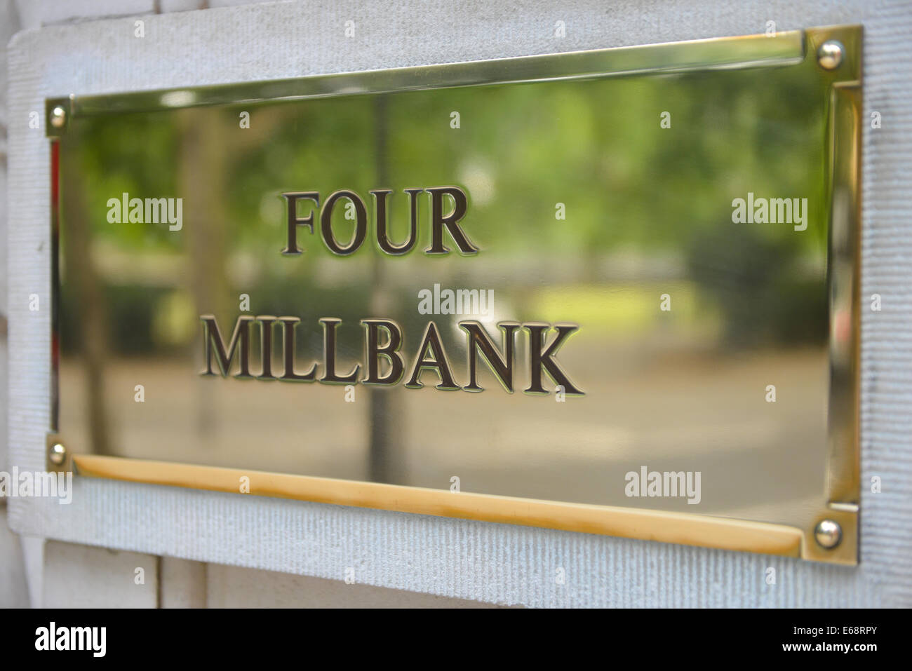 Quattro Millbank segno di ottone che riflettono le foglie degli alberi Foto Stock