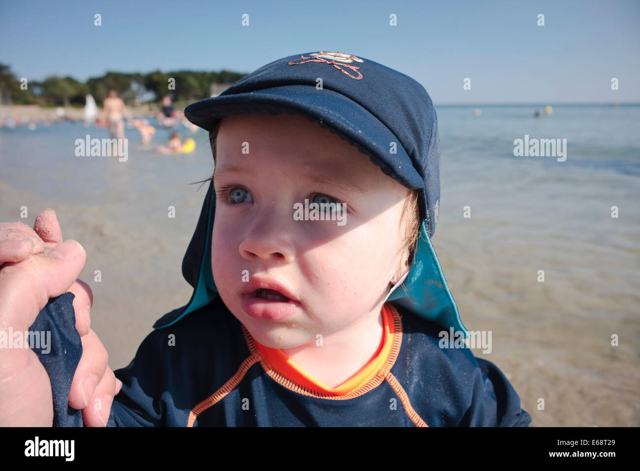 Un anno di vecchio ragazzo caucasico in vacanza indossando un cappello sulla spiaggia, La Trinité-sur-Mer, Bretagna Francia Foto Stock