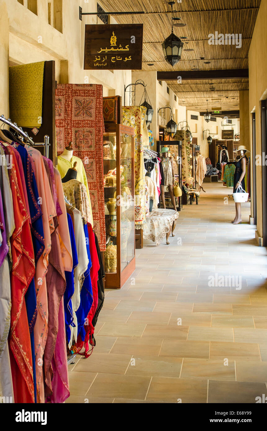 Shopping per i vestiti abbigliamento souvenir e prodotti tessili al Souk Madinat Jumeirah mercato, Dubai Emirati Arabi Uniti EMIRATI ARABI UNITI. Foto Stock