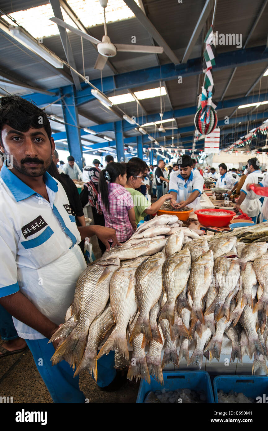 Pescatore con pesce in Deira mercato del pesce dal souk di Dubai, Emirati Arabi Uniti EMIRATI ARABI UNITI. Foto Stock