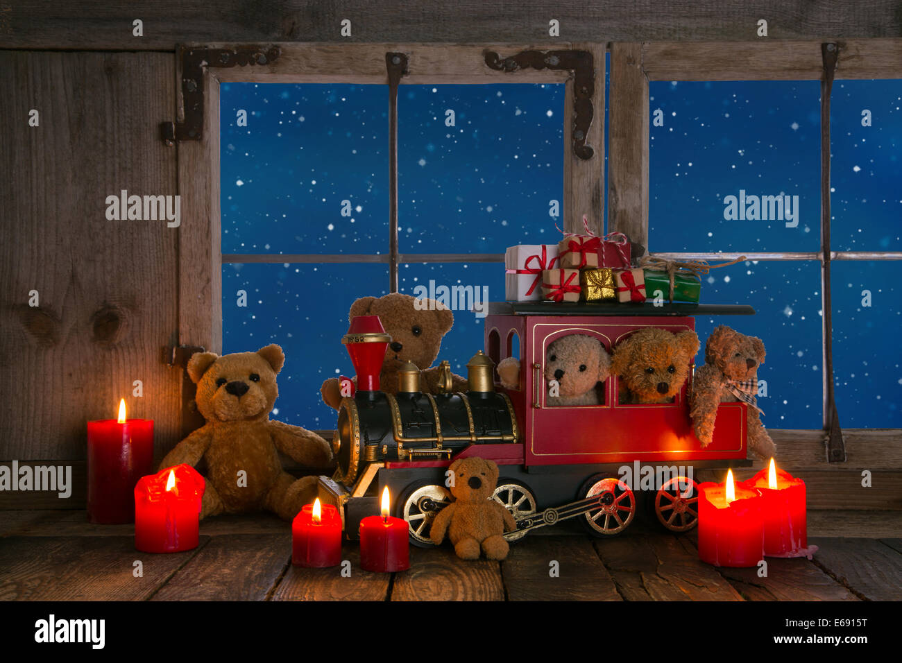 Orsacchiotto e candele rosse decorate su un vecchio davanzale sfondo con vista nella notte. Foto Stock