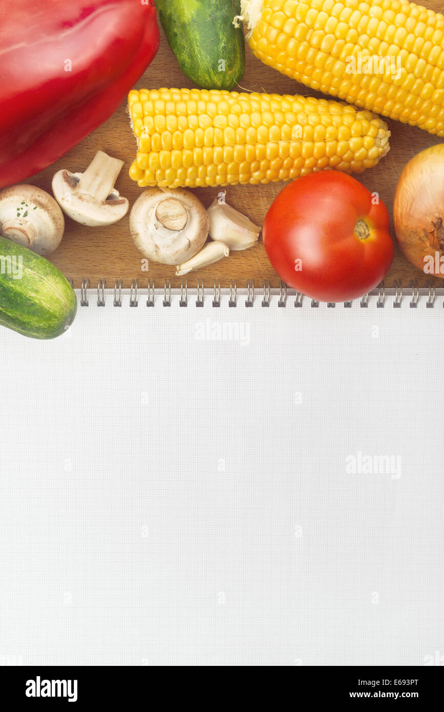 Mangiare sano; ricettario come copia di spazio e di varie materie verdura matura sul tavolo Foto Stock