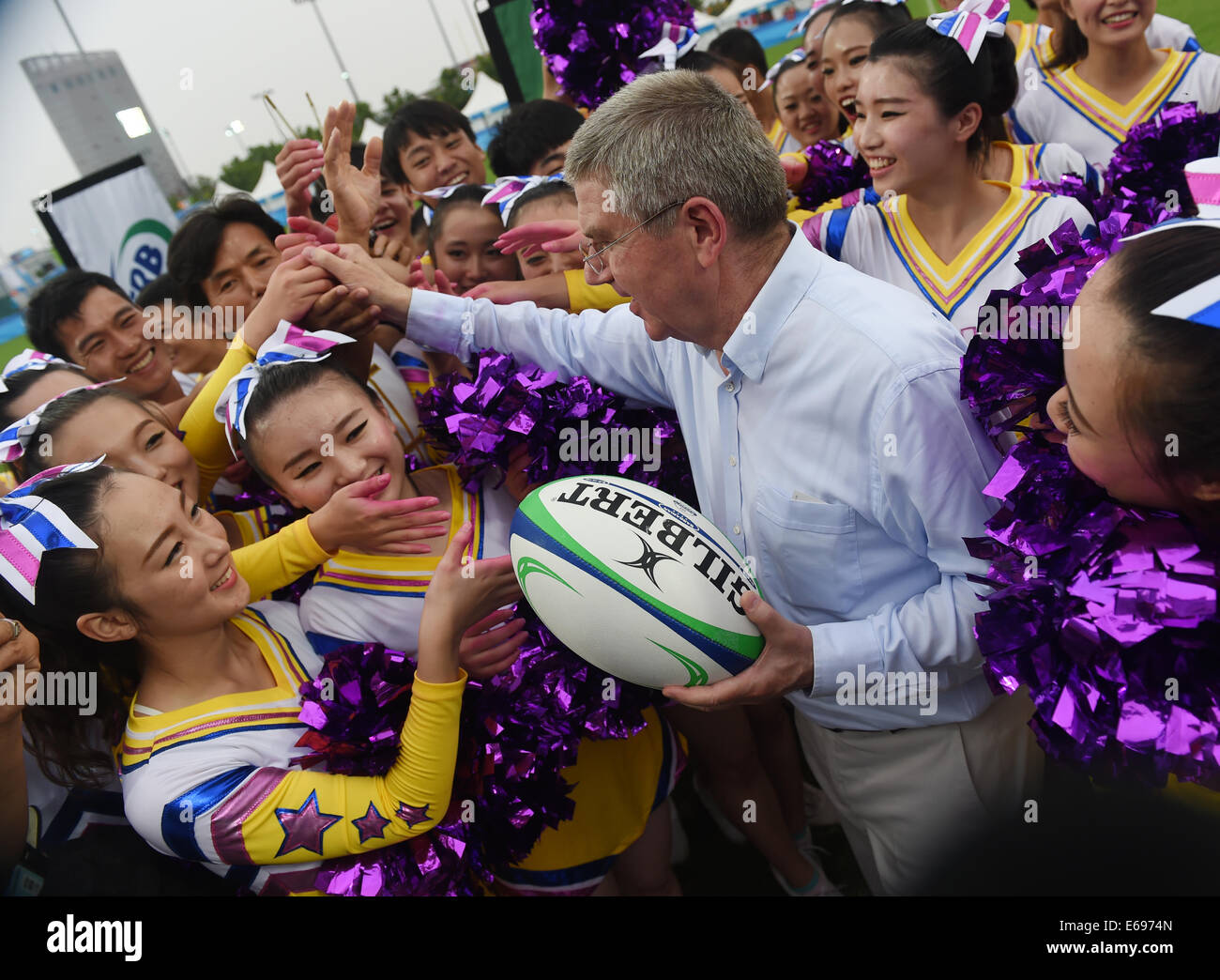 Nanjing, cinese della provincia di Jiangsu. 19 Ago, 2014. Il presidente del Comitato Olimpico Internazionale Thomas Bach saluta il personale e cheerleaders dopo la visione di donna Rugby Sevens evento presso la Nanjing 2014 Olimpiadi della Gioventù in Nanjing East cinese della provincia di Jiangsu, 19 Agosto, 2014. Credito: Yan Yan/Xinhua/Alamy Live News Foto Stock