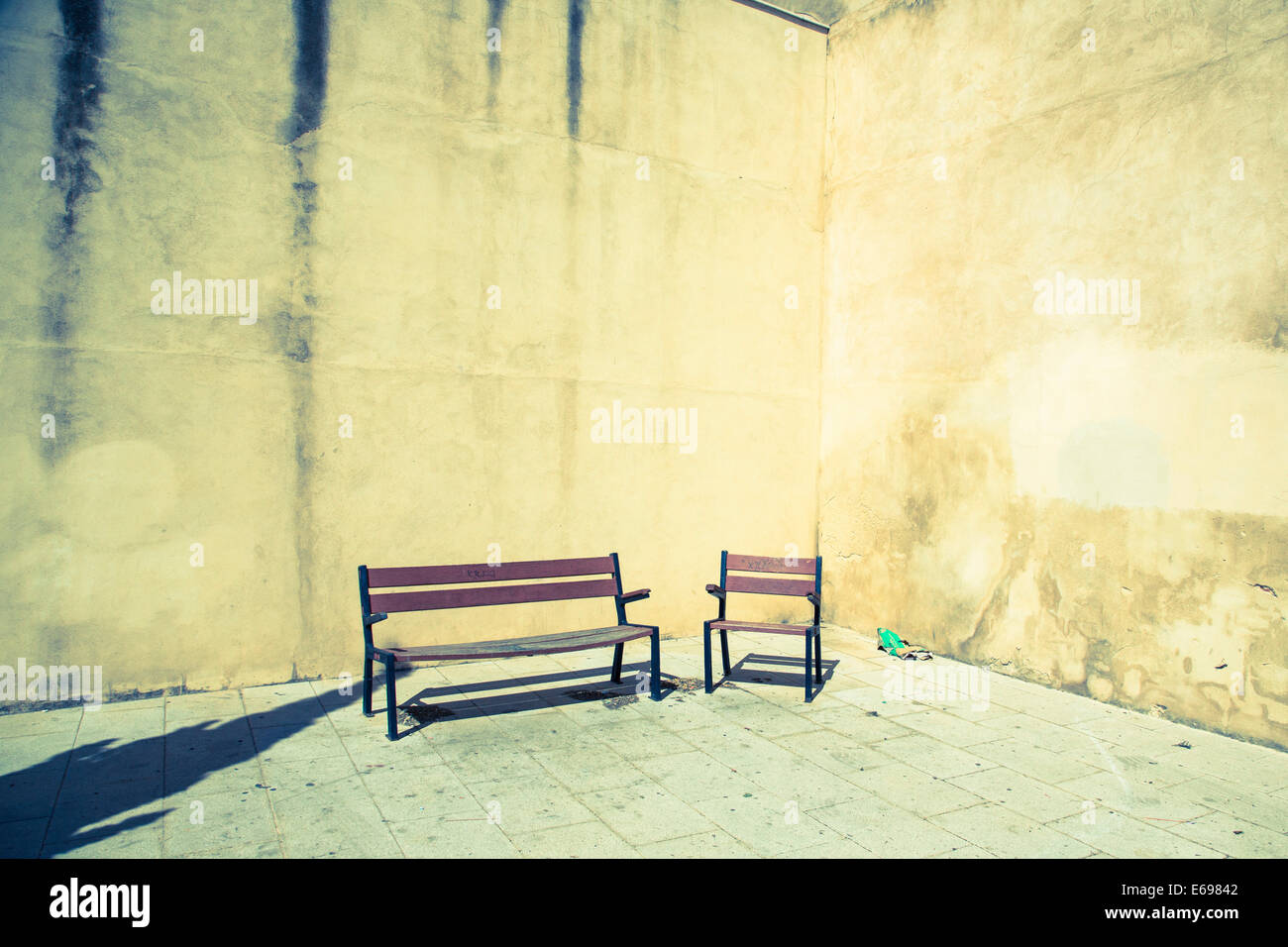 Sedia e panca davanti al muro di casa Foto Stock