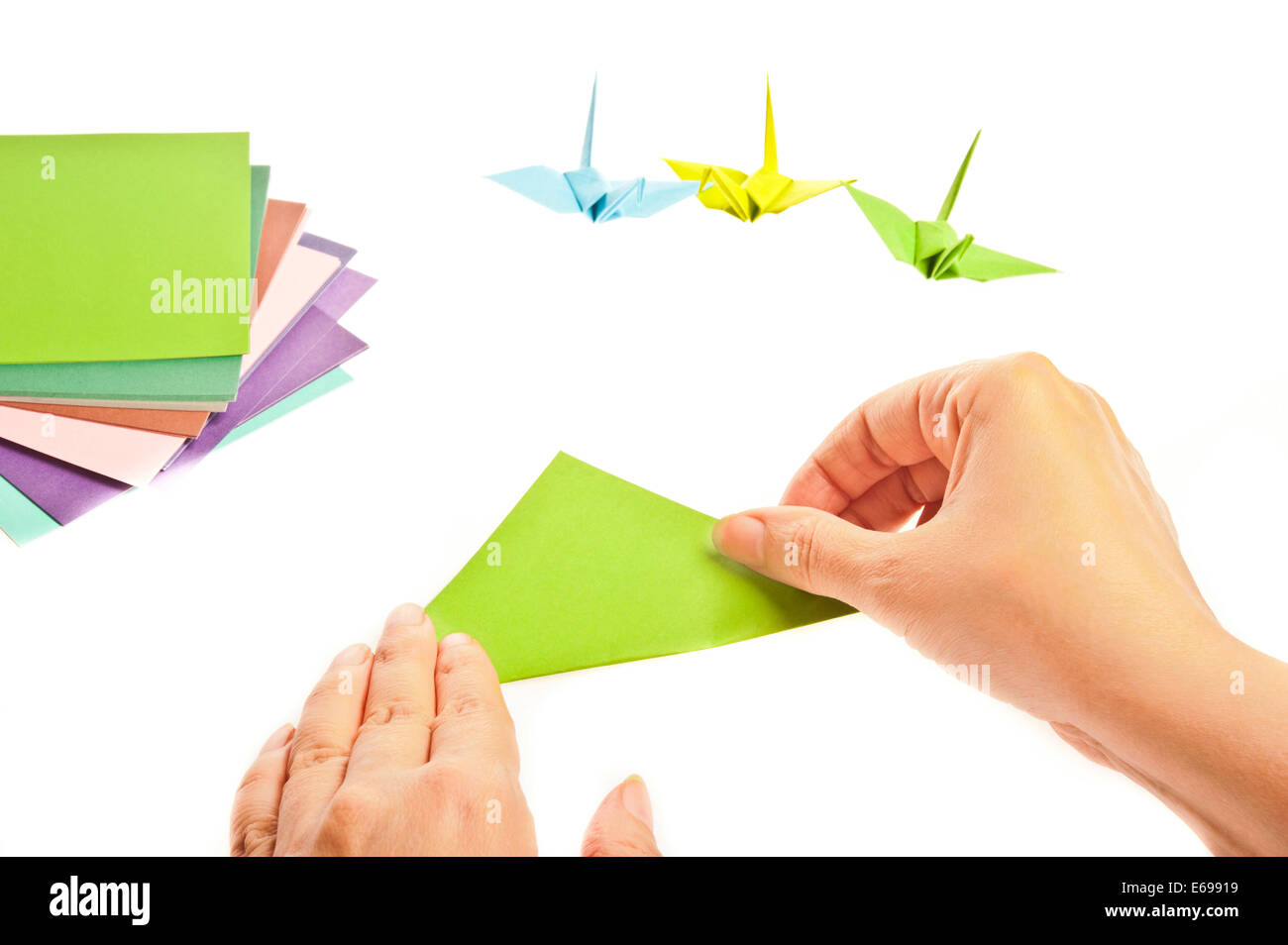 Le mani la piegatura di un uccello origami Foto Stock