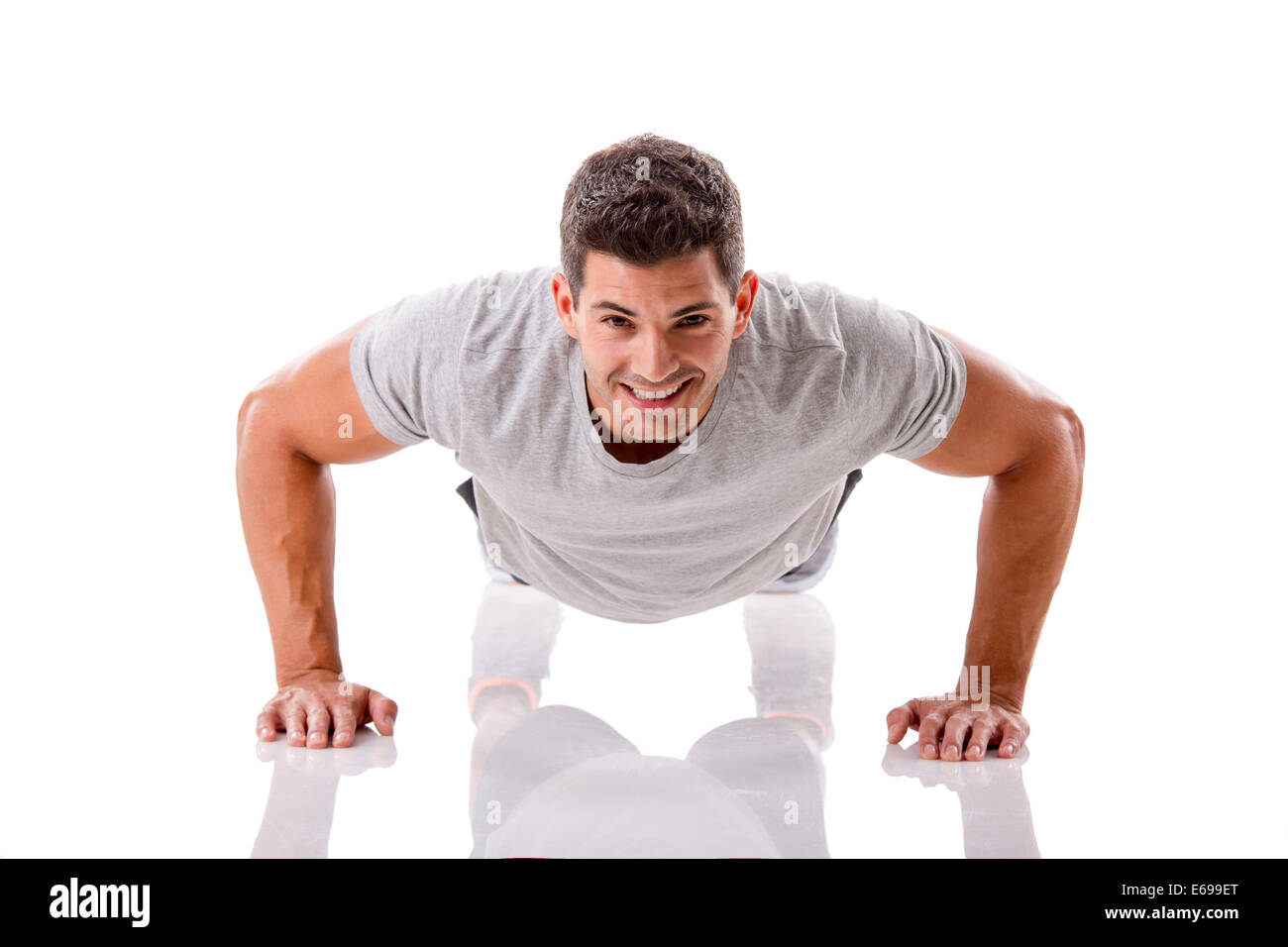 Uomo che fa pushups in studio, isolate su uno sfondo bianco Foto Stock