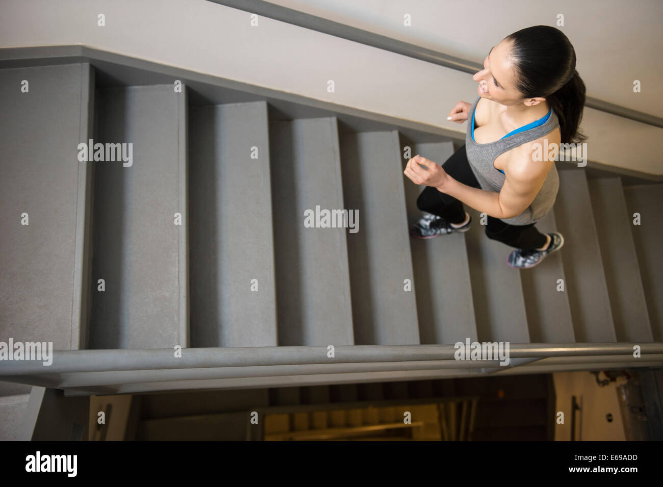 La donna caucasica in esecuzione su per le scale Foto Stock