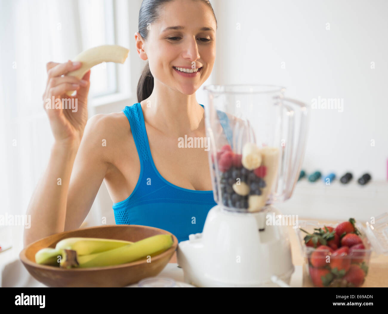 La donna caucasica blending frullato di frutta Foto Stock