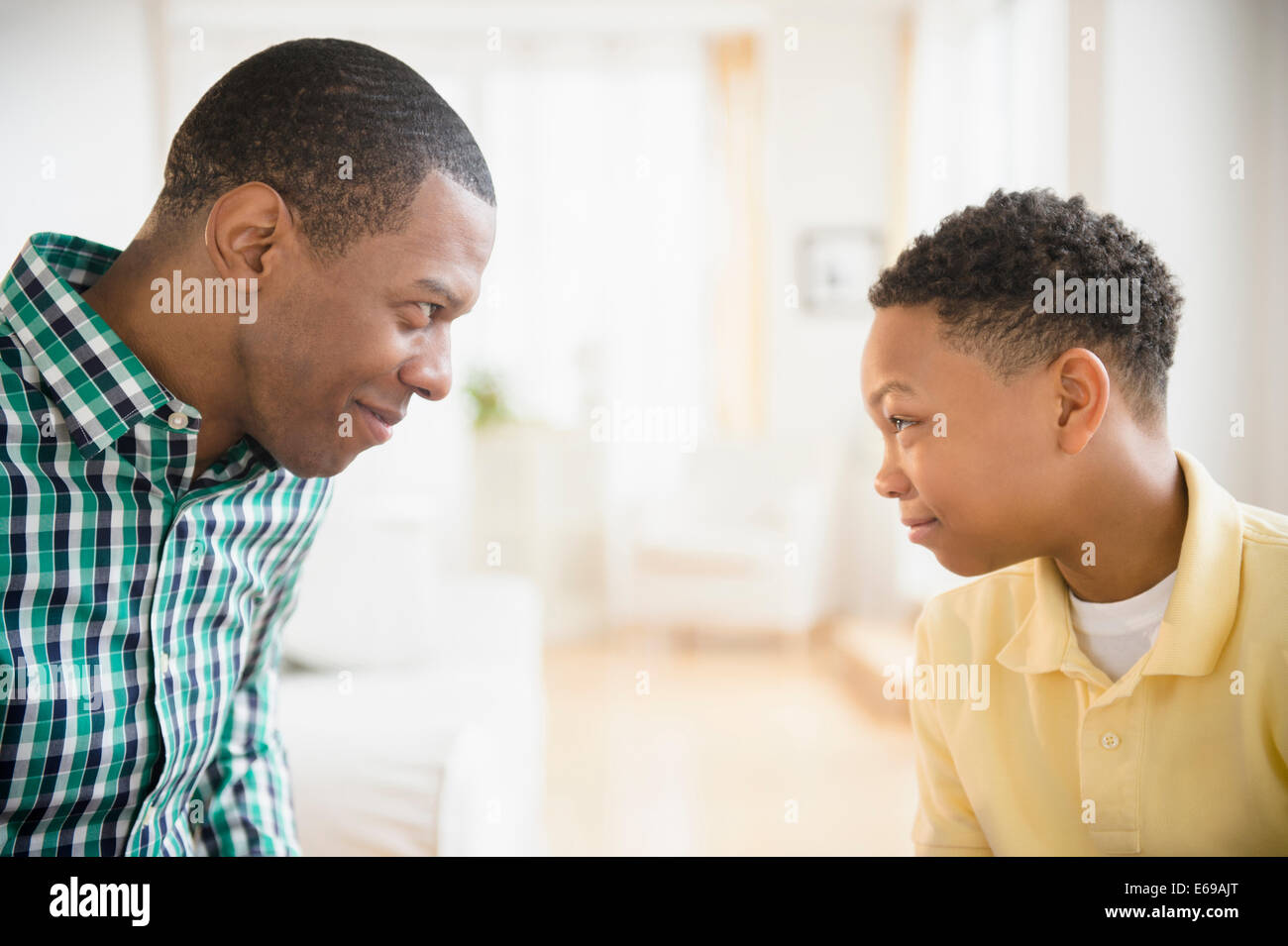 Padre e figlio facendo facce a ciascun altro Foto Stock