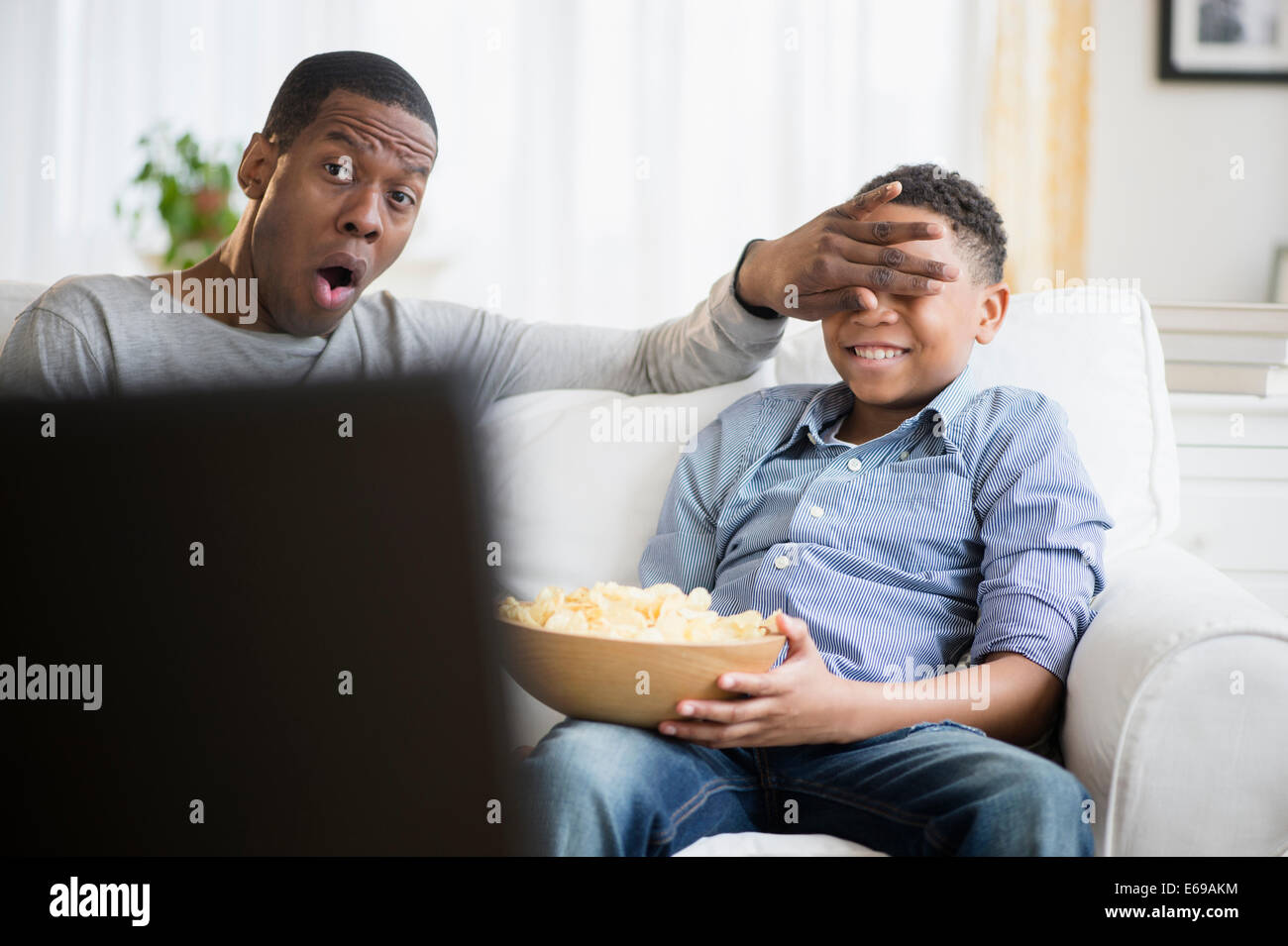 Padre e figlio di guardare la televisione sul divano Foto Stock