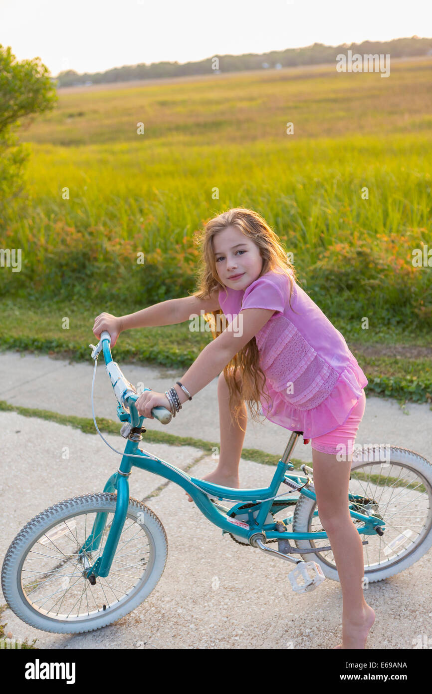 Ragazza caucasica equitazione bicicletta su strada rurale Foto Stock
