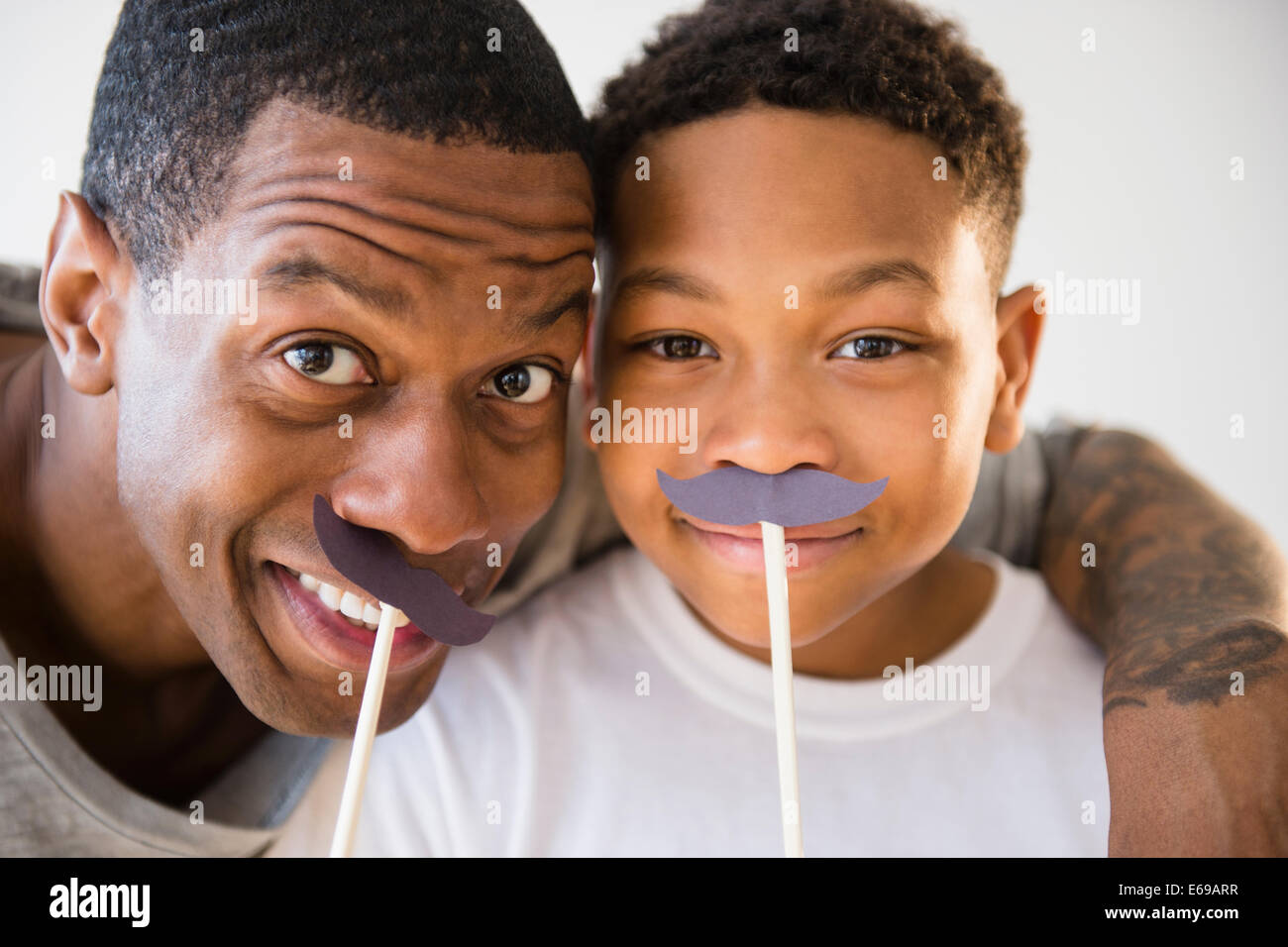 Padre e figlio giocando con il fake mustaches Foto Stock