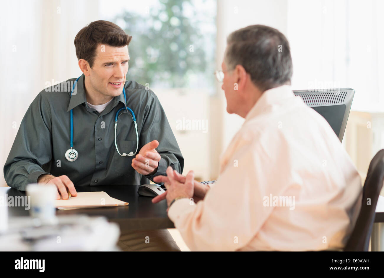 Caucasian il medico e il paziente parla in office Foto Stock