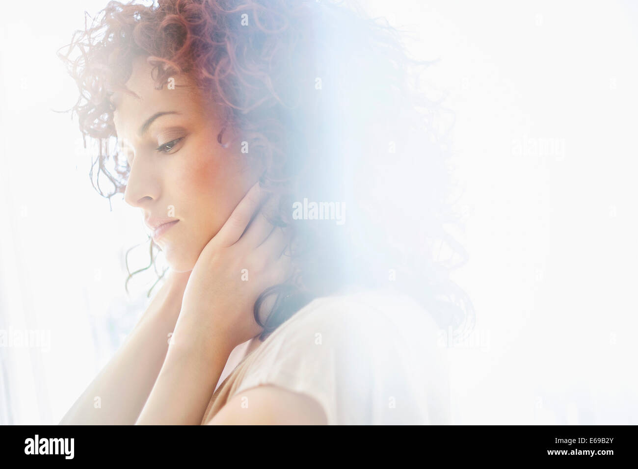 Donna ispanica holding mento in mani Foto Stock