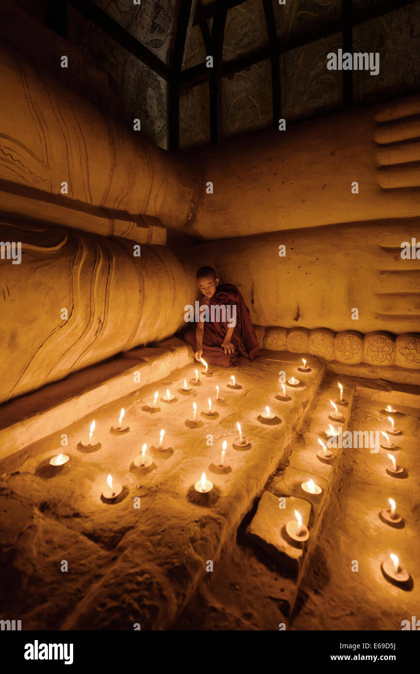Monaco asiatici accendendo candele nel tempio Foto Stock