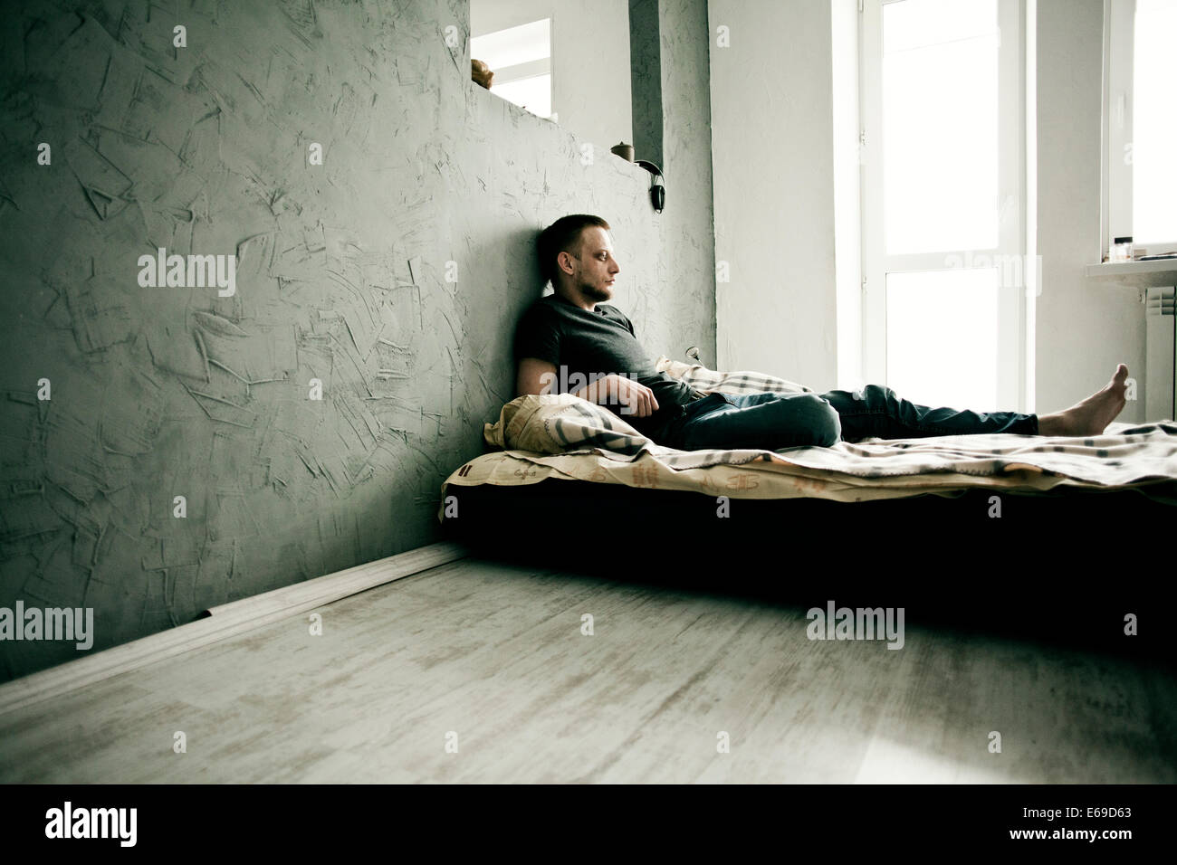 Uomo caucasico posa sul letto Foto Stock