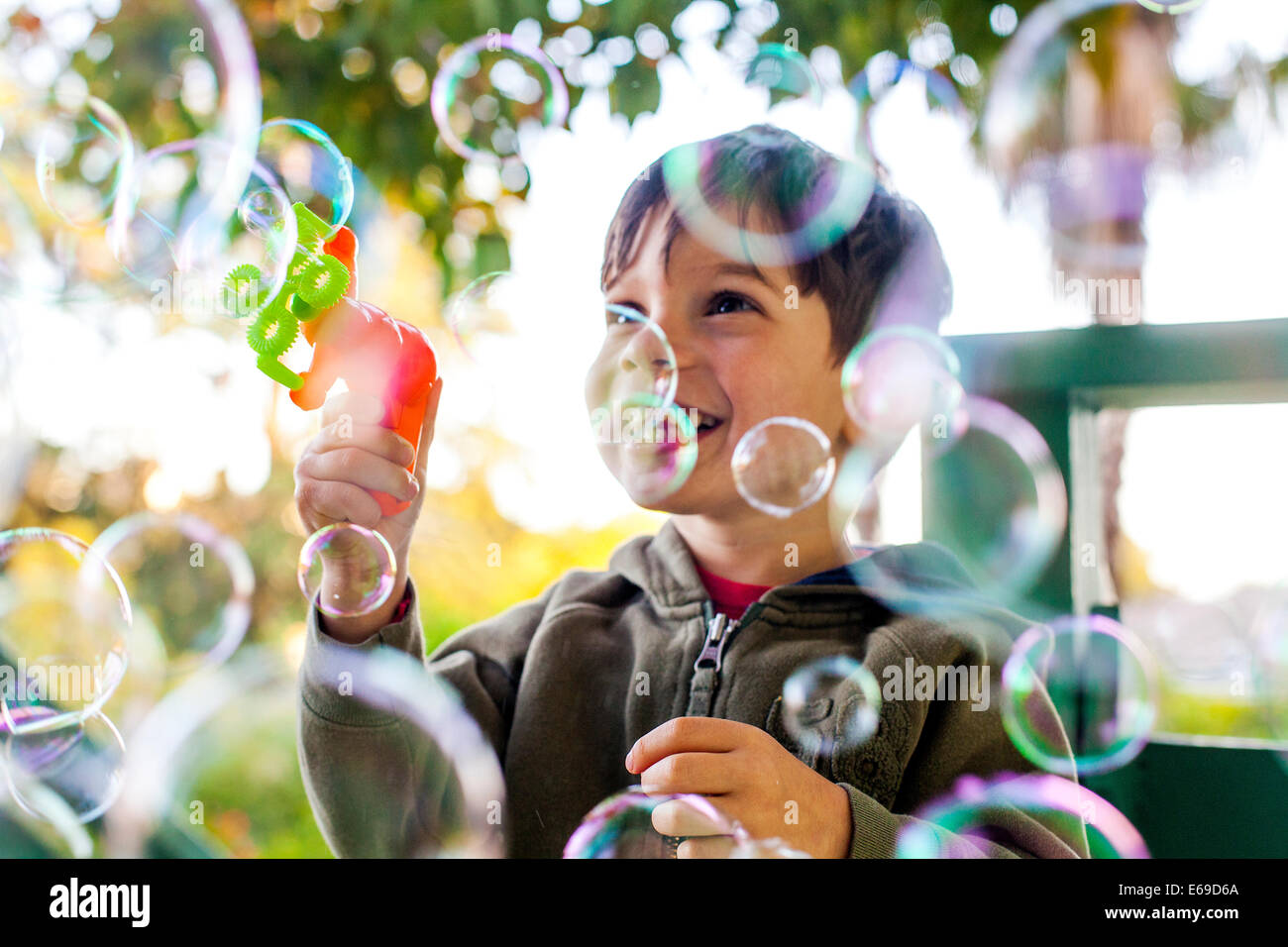 Razza mista ragazzo giocando con bolle all'aperto Foto Stock