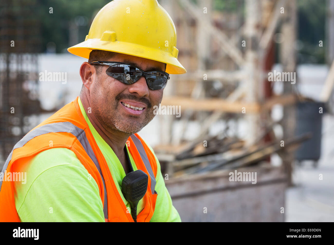 Lavoratore ispanica sorridente al sito in costruzione Foto Stock