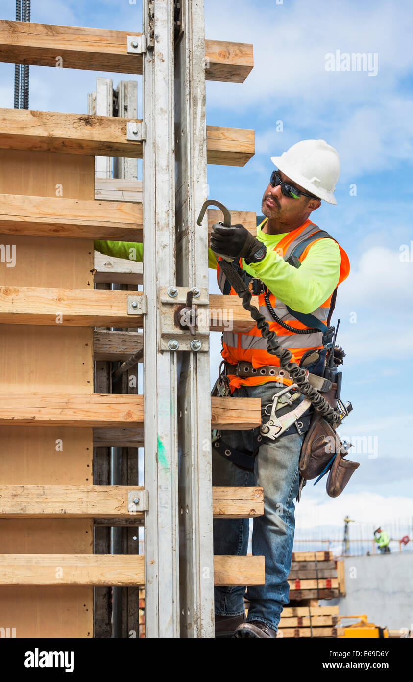 Lavoratore ispanica tenendo il gancio sul sito in costruzione Foto Stock