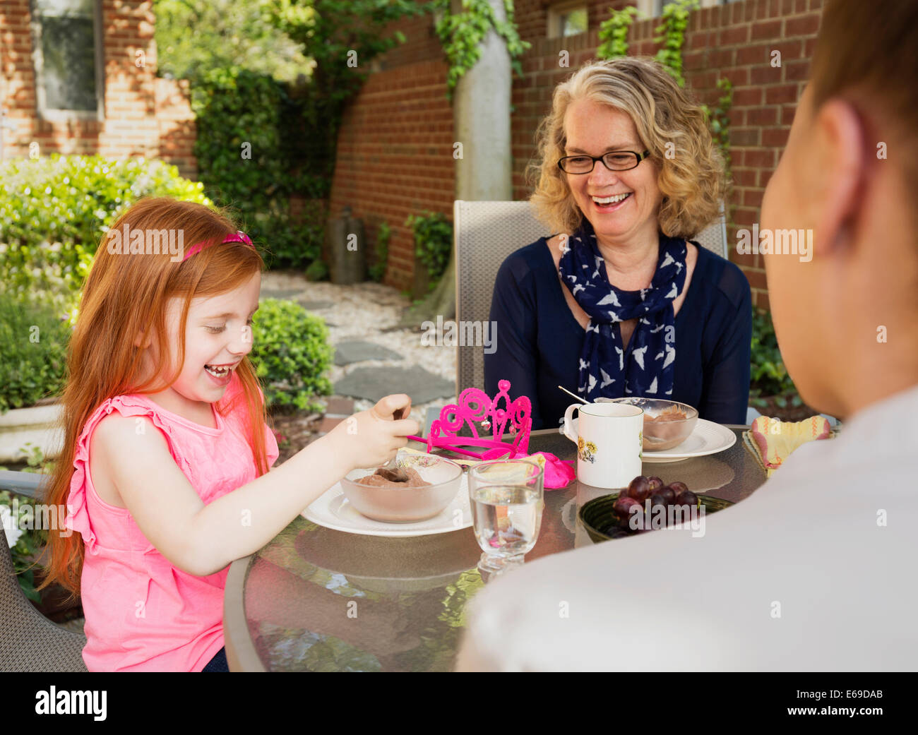 Famiglia caucasica mangiare insieme nel cortile posteriore Foto Stock
